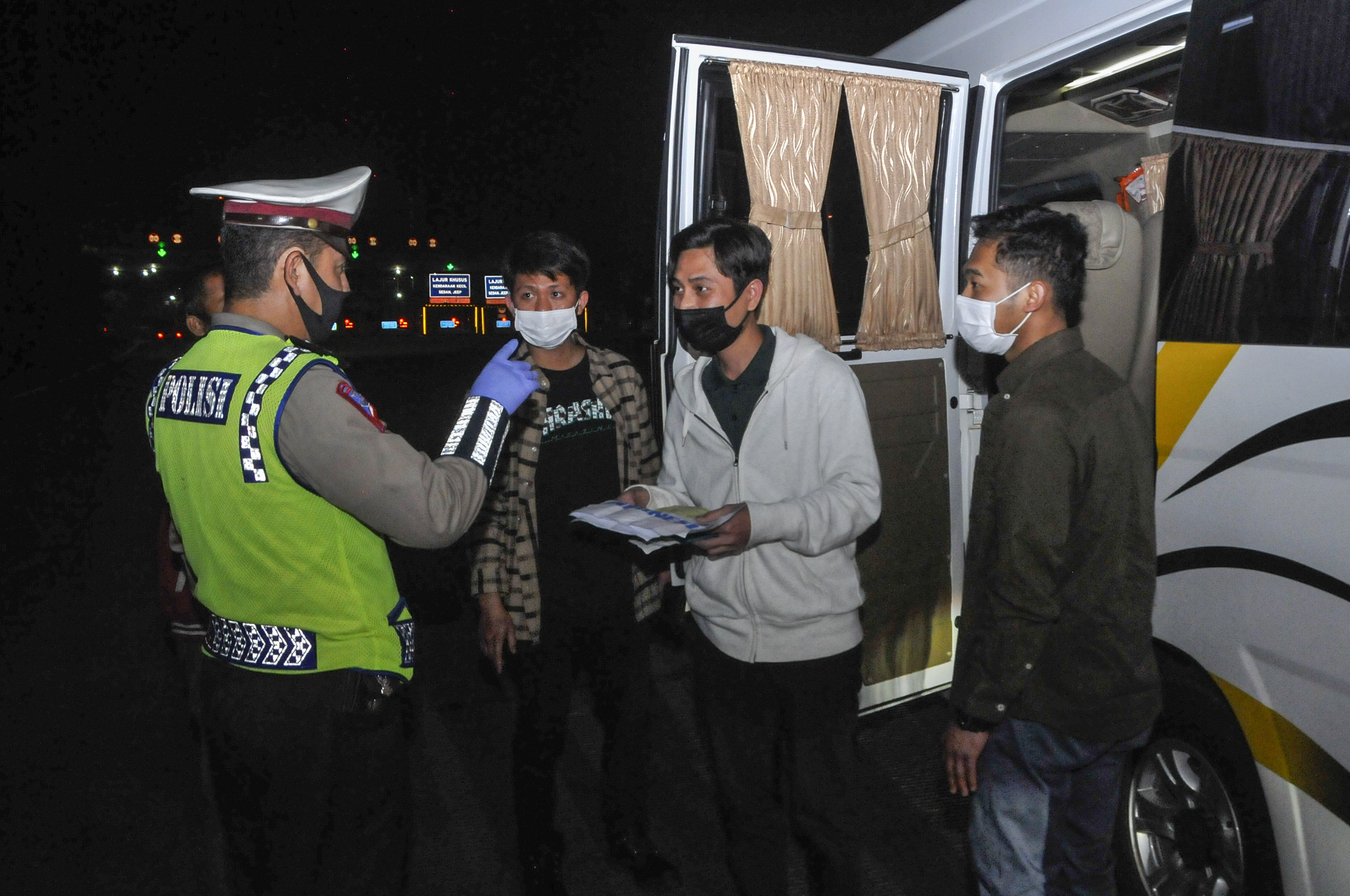 Polisi memeriksa surat tiga orang TKI (Tenaga Kerja Indonesia) dari luar negeri di tol Jakarta-Cikampek, Cikarang, Kabupaten Bekasi.