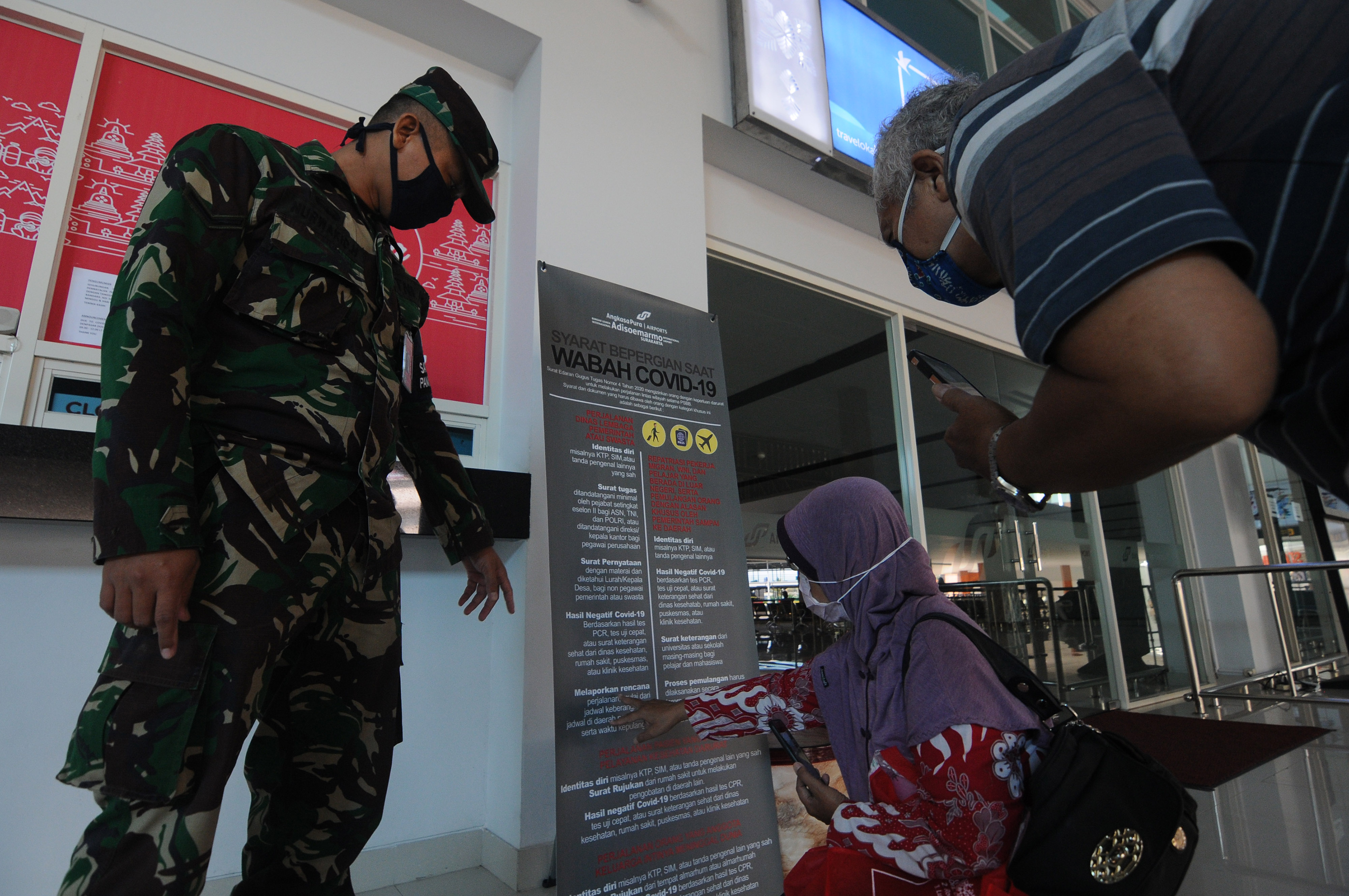 Prajurit TNI memberikan petunjuk soal syarat warga yang boleh melakukan arus balik di Bandara Adi Soemarno Solo