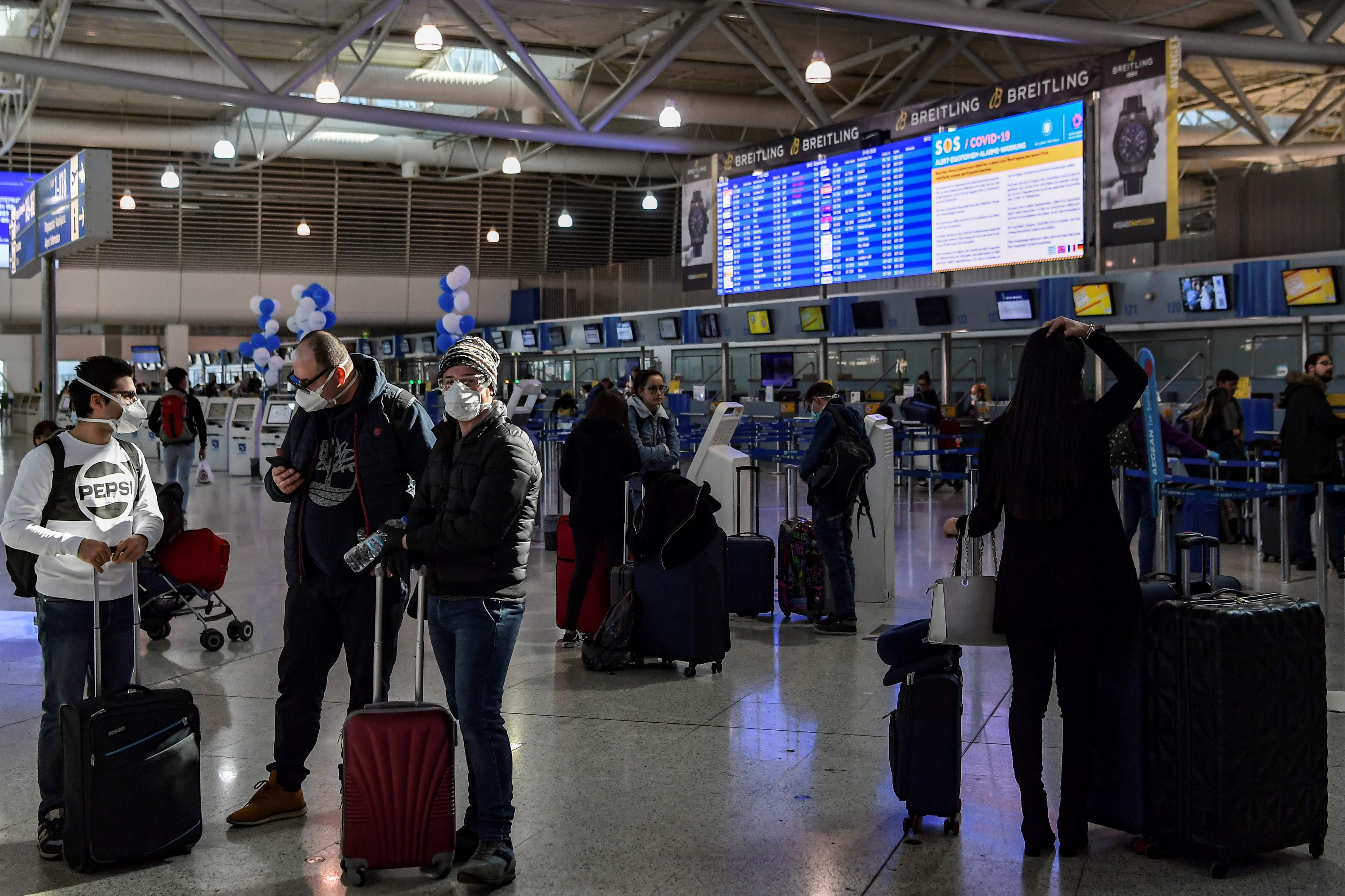 Pelancong mengenakan masker di Bandara Internasional Athena, Yunani