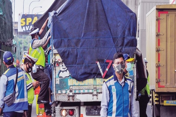 Anggota polisi dan Dinas Perhubungan naik ke truk untuk memeriksa muatan yang melintas di Tol Jakarta-Cikampek di Cikarang Barat, kemarin