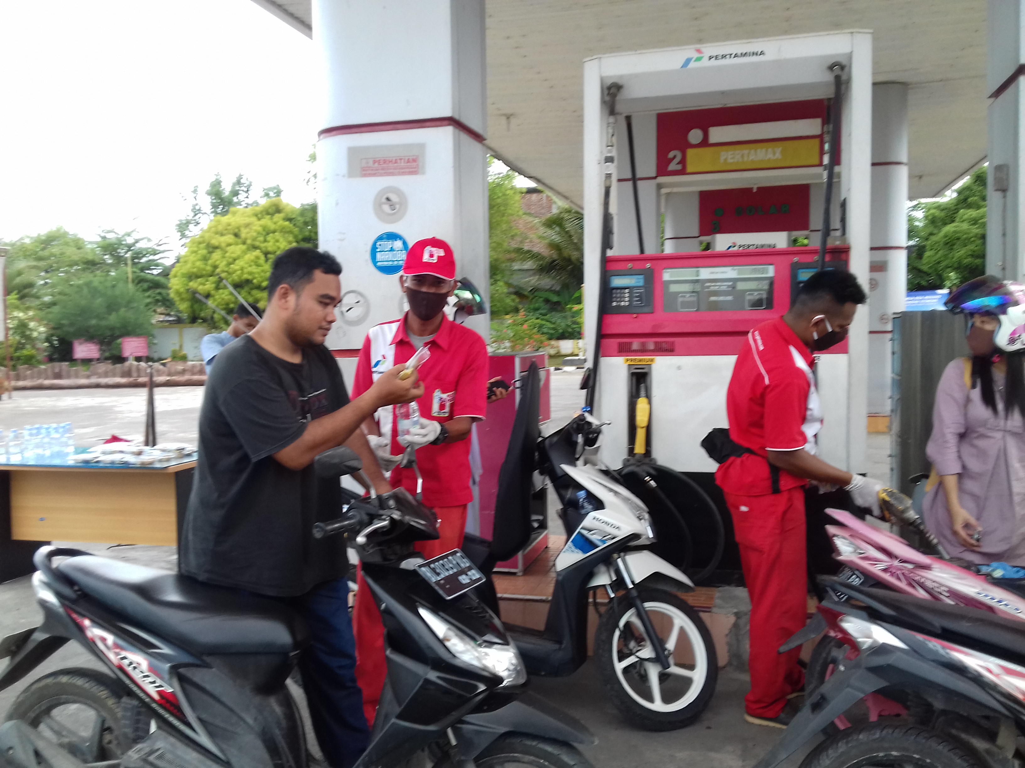 Petugas SPBU Sigli, Kabupaten Pidie, Provinsi Aceh, sedang membagikan takjil berbuka kepada warga, Minggu (3/5/2020)