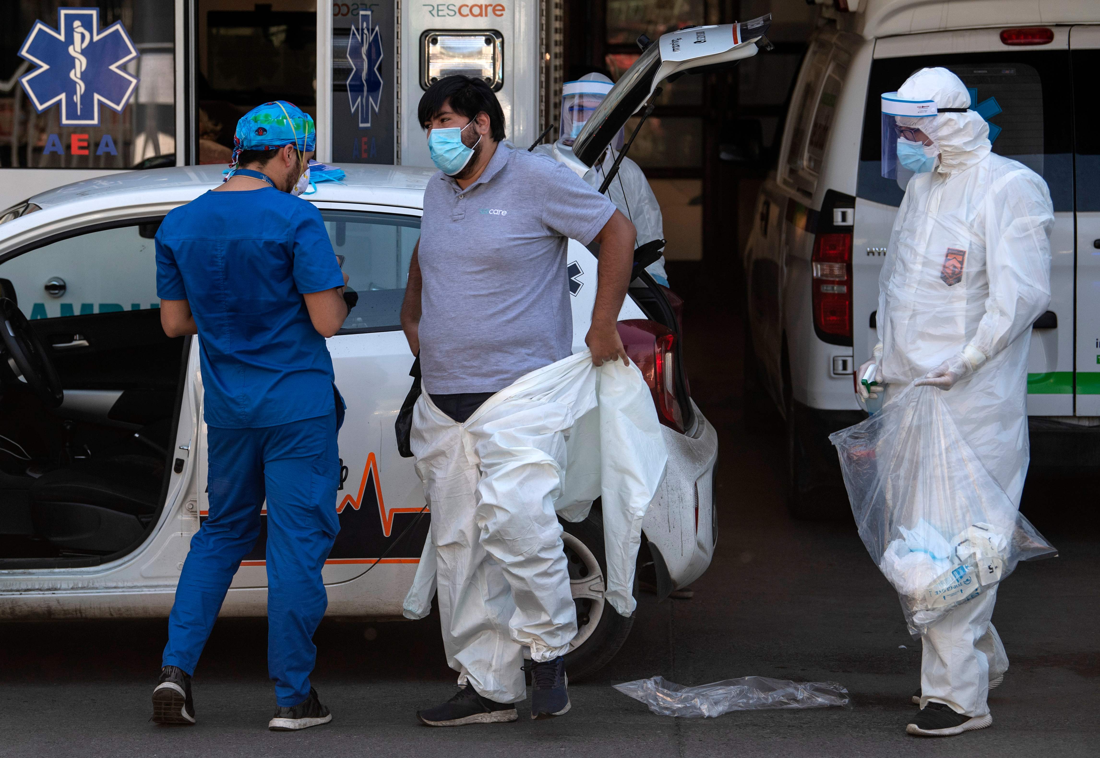 Seorang pekerja kesehatan mengenakan APD di luar sebuah rumah sakit di Santiago, Cile.