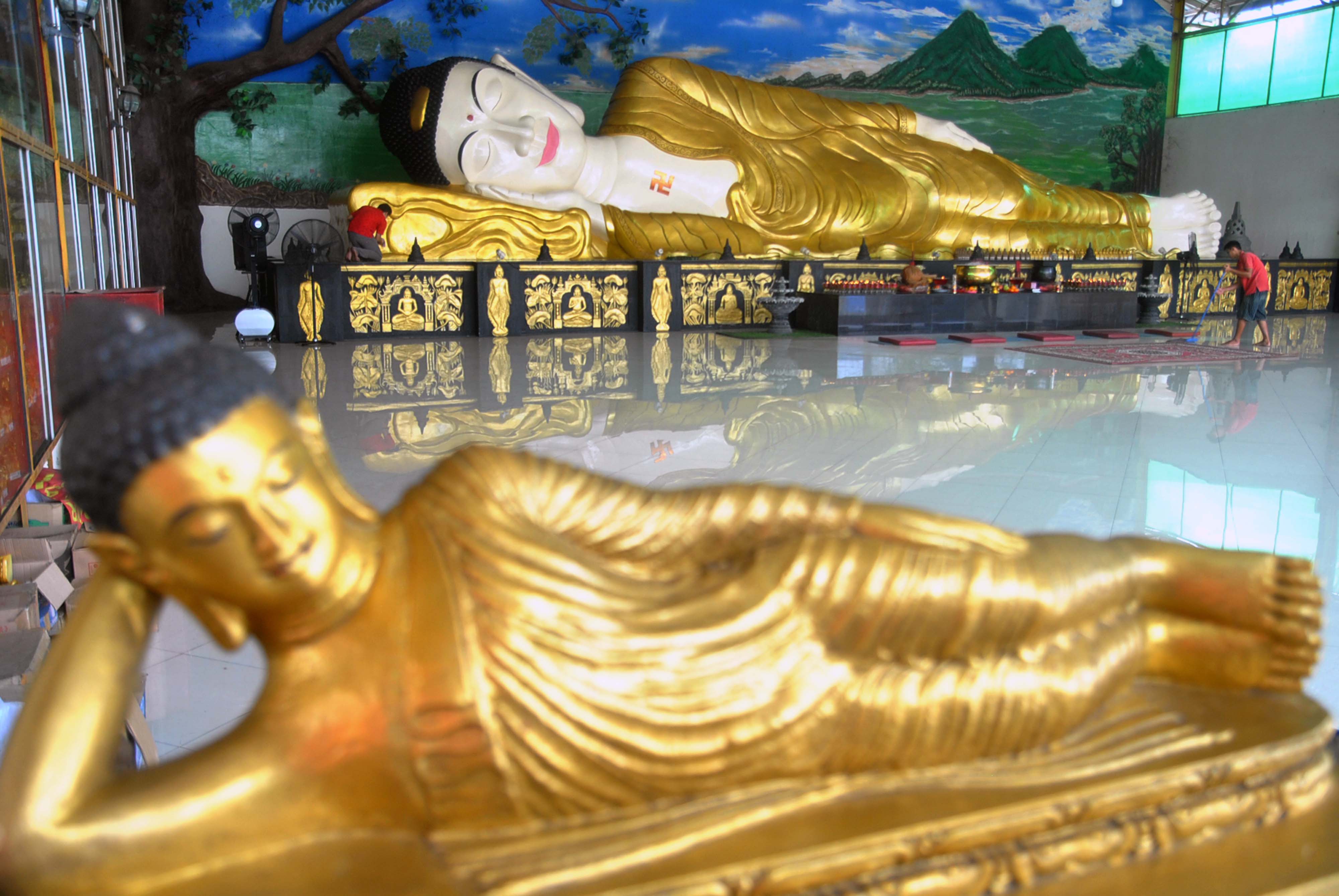 Pekerja membersihkan patung Buddha di Vihara Buddha Dharma dan 8 Pho Sat, Kampung Jati, Desa Tonjong, Tajurhalang, Kabupaten Bogor.