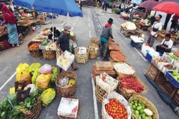Sejumlah pedagang menyiapkan barang di lapak yang telah diatur jaraknya di area parkir Pasar Badung, Denpasar, Bali, kemarin
