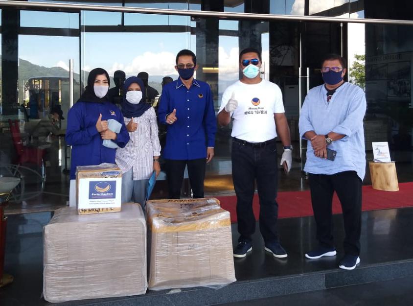 Ketua DPW NasDem Malut Ishak Naser (kaos putih) menyerahkan bantuan APD untuk tenaga kesehatan di Hotel Sahid Bela, Senin (11/5/2020)