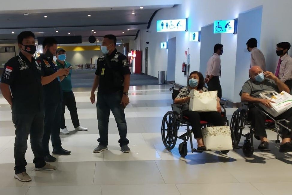 Buronan Shamdepchand Mahboobhani (kanan) mengunakan kursi roda ditemani istrinya saat akan dibawa oleh aparat.