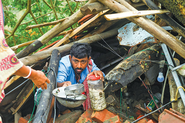 Warga menyelamatkan barang-barang dari rumah mereka yang rusak akibat terjangan topan Amphan di Midnapore, Bengal, India