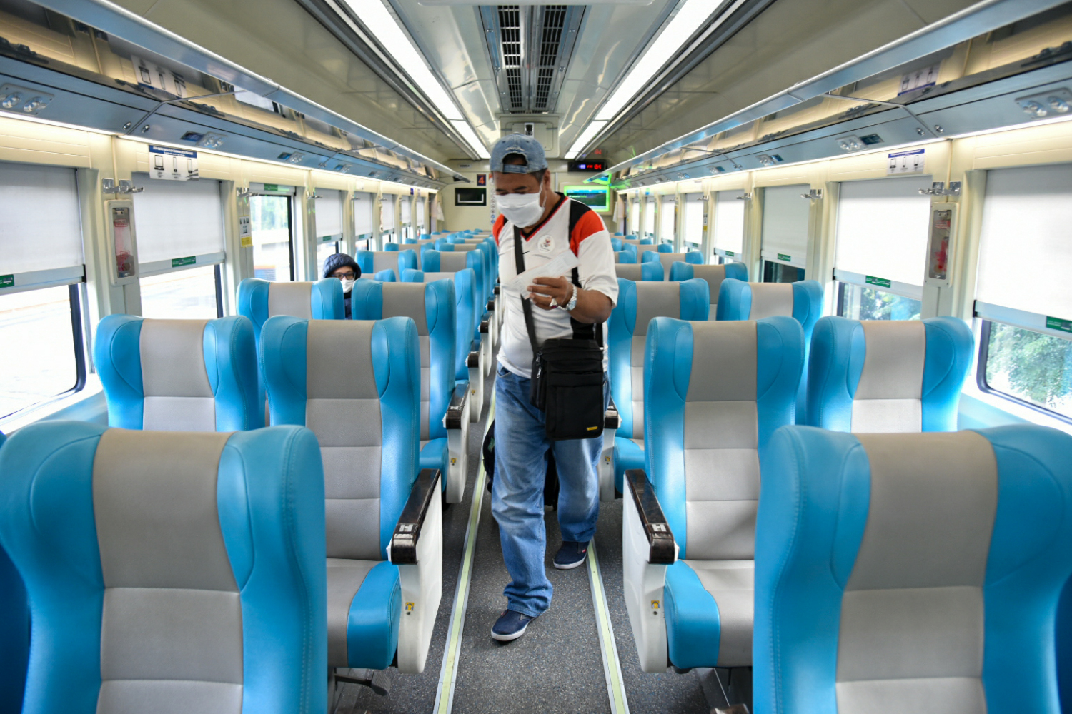 Penumpang mengenakan masker di dalam gerbong kereta api luar biasa relasi Gambir-Surabaya Pasar Turi di Stasiun Gambir, Jakarta.