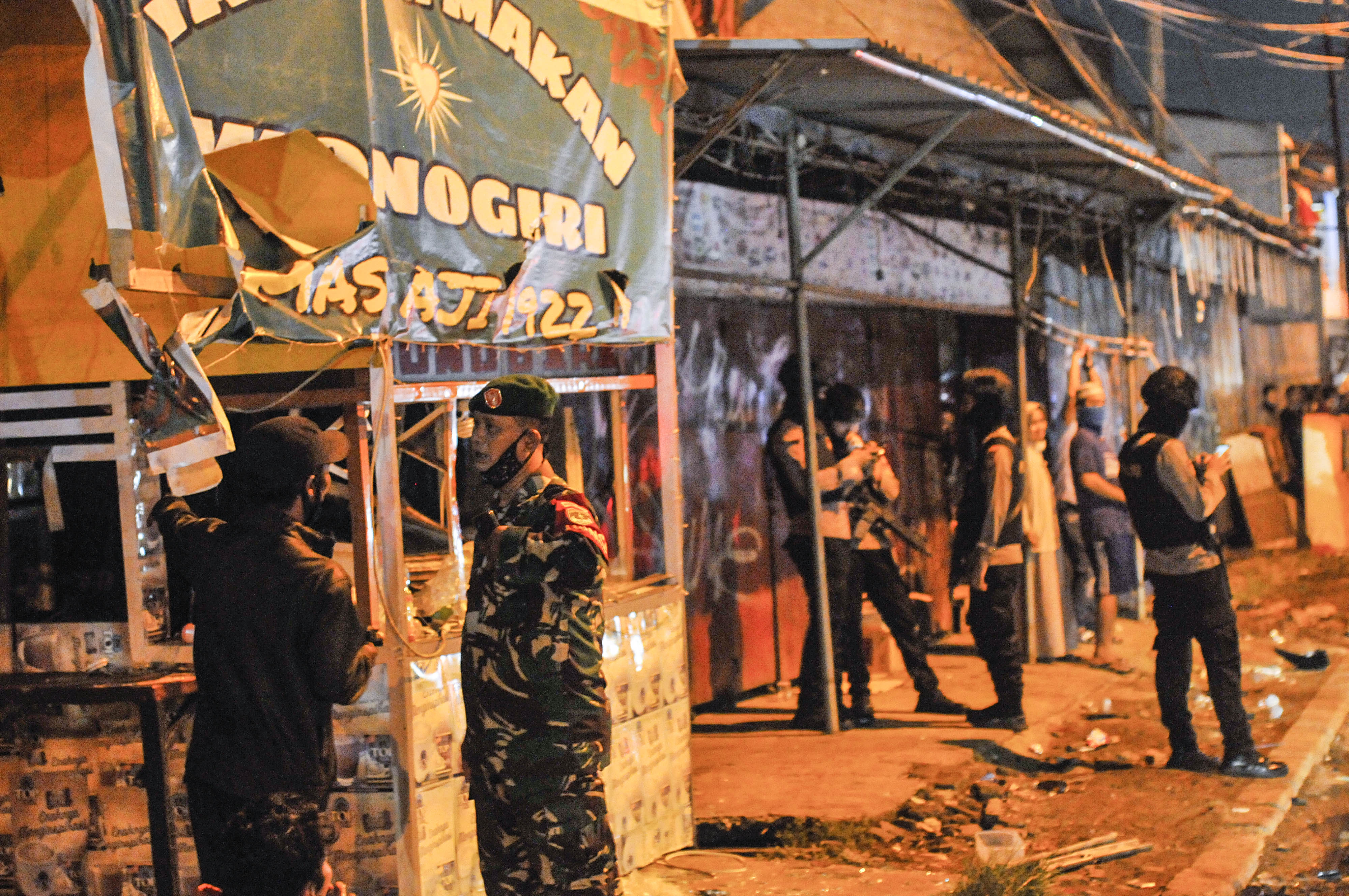 Sejumlah petugas kepolisian dan TNI berjaga di ruko yang rusak pascabentrokan ormas di Kranji, Bekasi, Jawa Barat, Kamis (21/5).