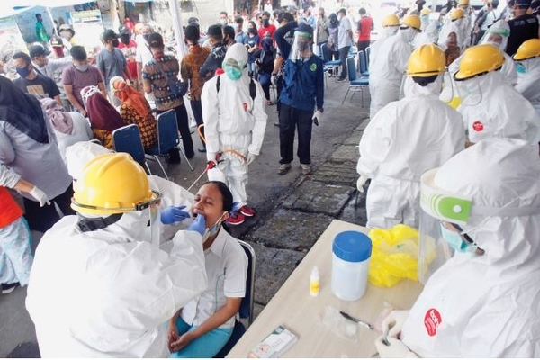 Petugas medis mengambil sampel saat tes swab di Pasar Kebon Kembang, Kota Bogor, Jawa Barat, kemarin.