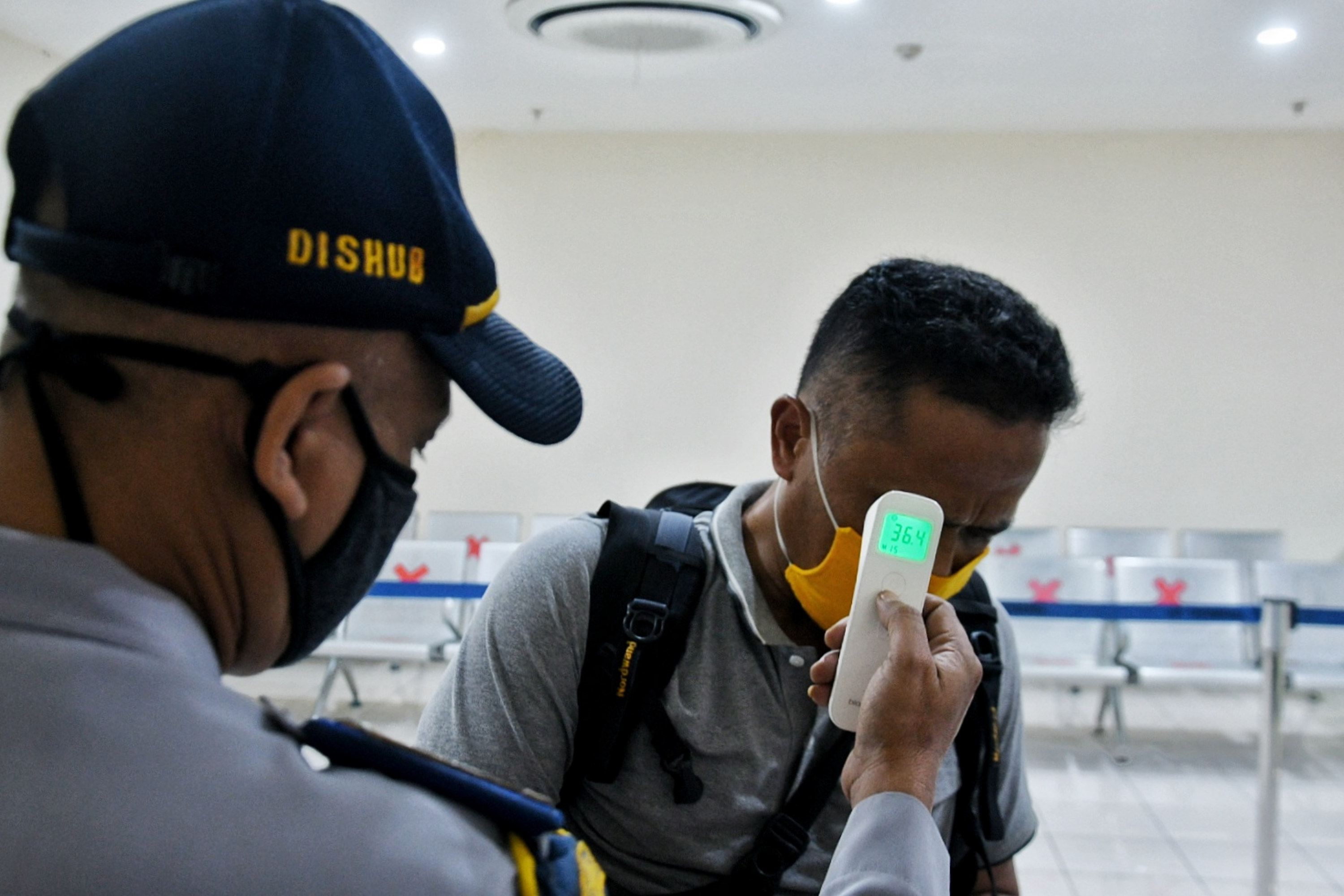 Petugas mengecek berkas perjalanan dan suhu tubuh penumpang di Terminal Pulo Gebang, Minggu (10/5).