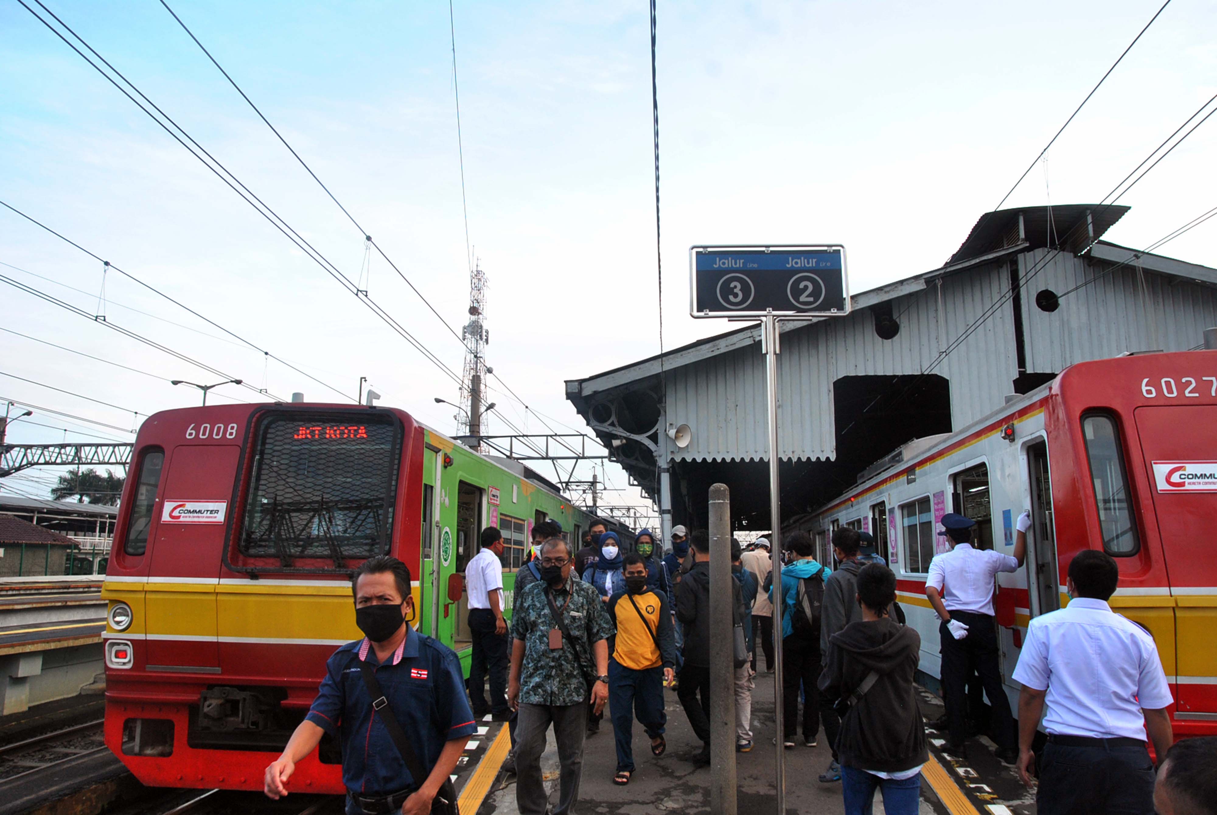 Penumpang berjalan di dekat gerbong KRL Commuter Line di Stasiun Bogor, Jawa Barat.