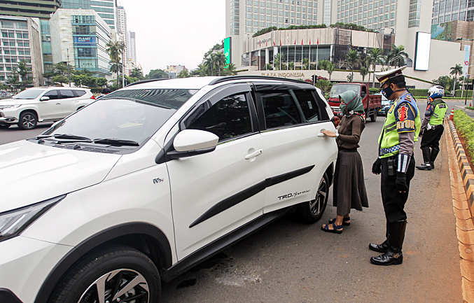 Petugas gabungan dari Kepolisian Polda Metro Jaya dan Dishub Pemprov DKI melakukan penindakan pelanggaran PSBB di Bundaran HI (9/5)