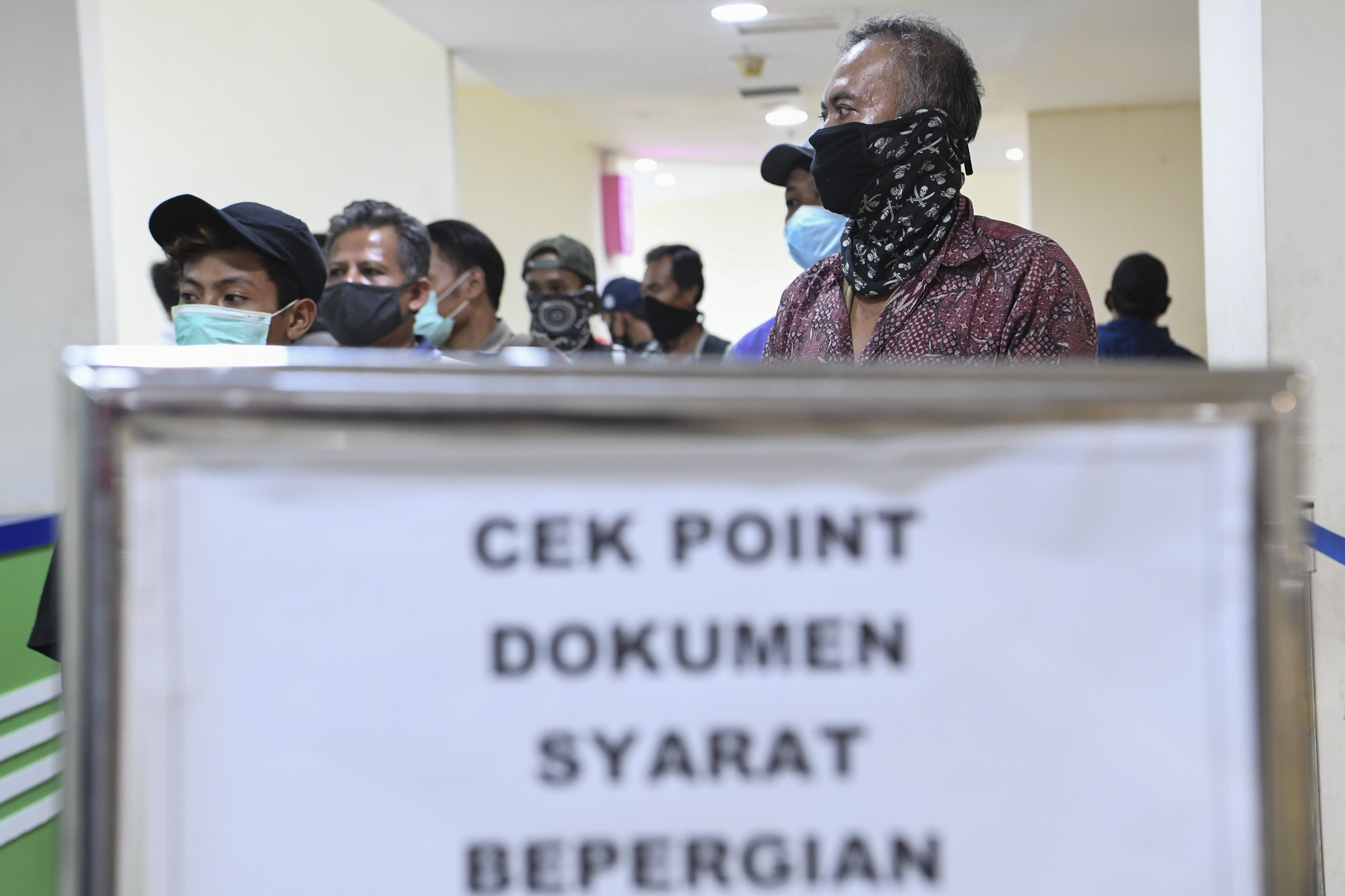 Calon penumpang yang akan berpergian menggunakan Bus AKAP mengantre untuk diperiksa dokumennya di Terminal Pulogebang, Jakarta.