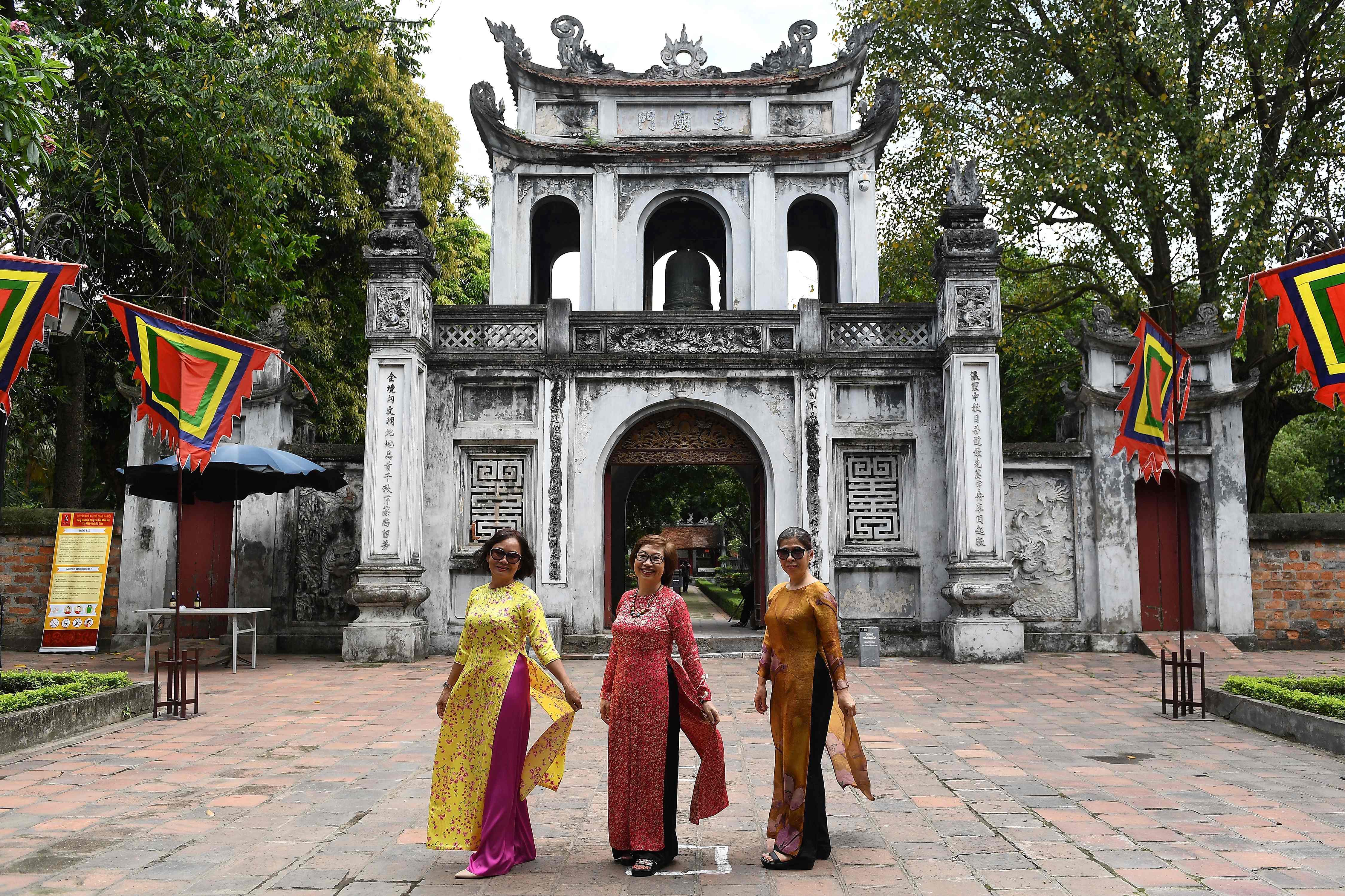 Wisatawan berpose di depan Temple of Literature di Hanoi pada 14 Mei 2020