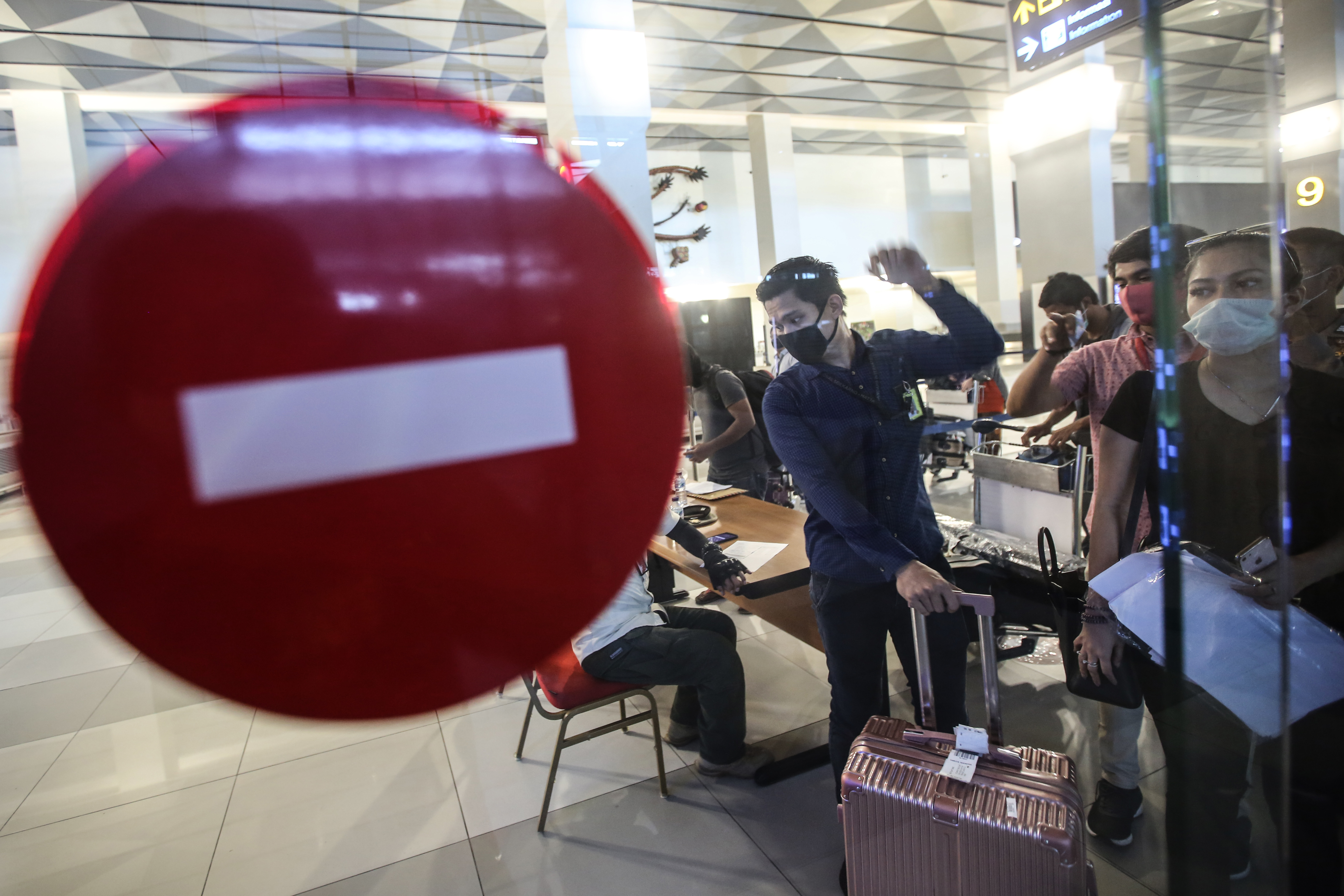 Penumpang antre pemeriksaan surat izin keluar/masuk (SIKM), surat tugas, surak kesehatan dan hasil tes covid-19.