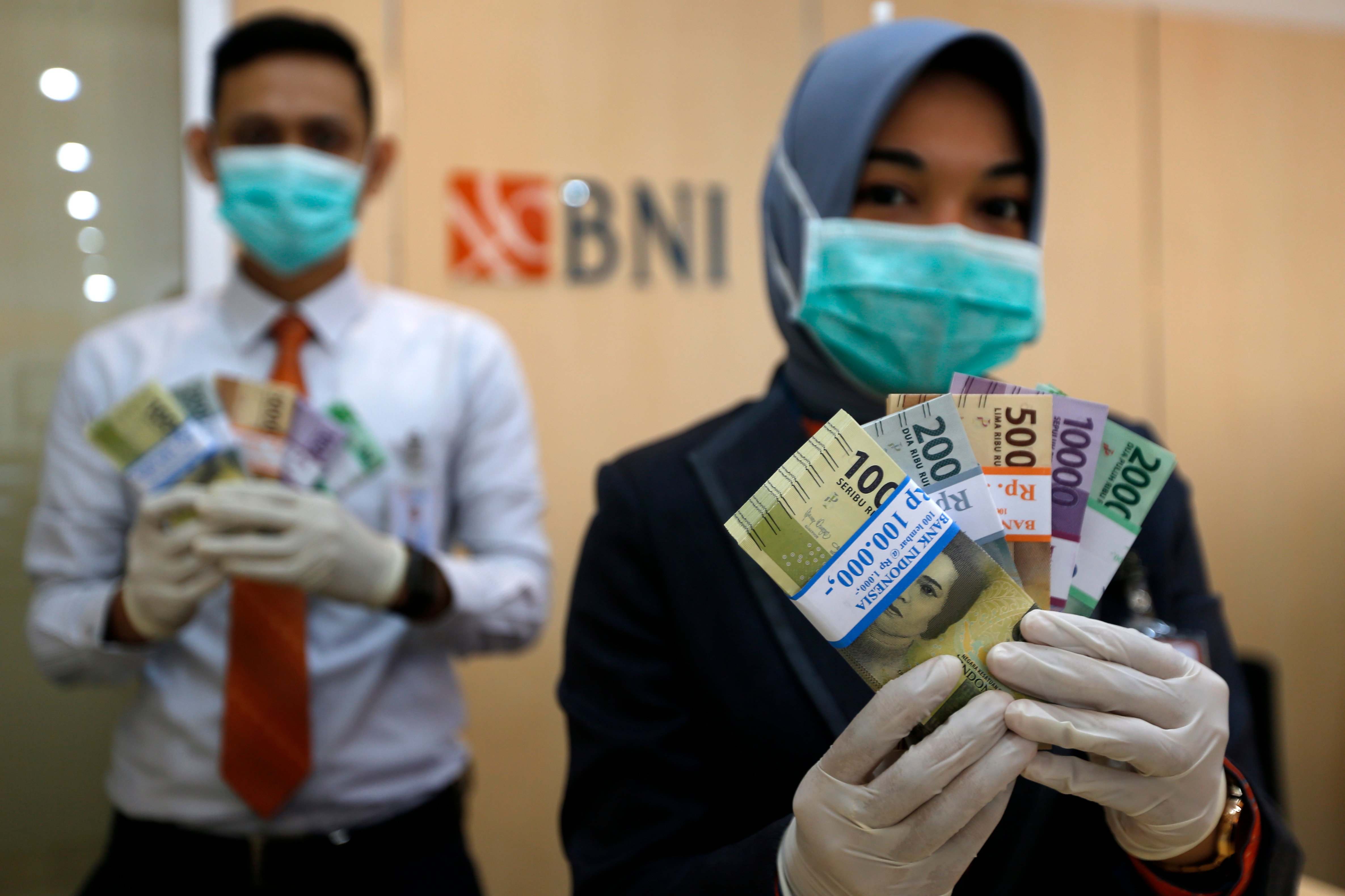  Petugas Bank Negara Indonesia (BNI) Cabang Banda Aceh memperlihatkan uang pecahan yang dipersiapkan untuk memenuhi kebutuhan penukaran.