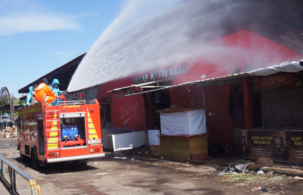  Petugas menyemprotkan cairan disinfektan di Pasar Antri Cimahi, Minggu (24/5) setelah dua pedagang terkonfirmasi Covid-19. 