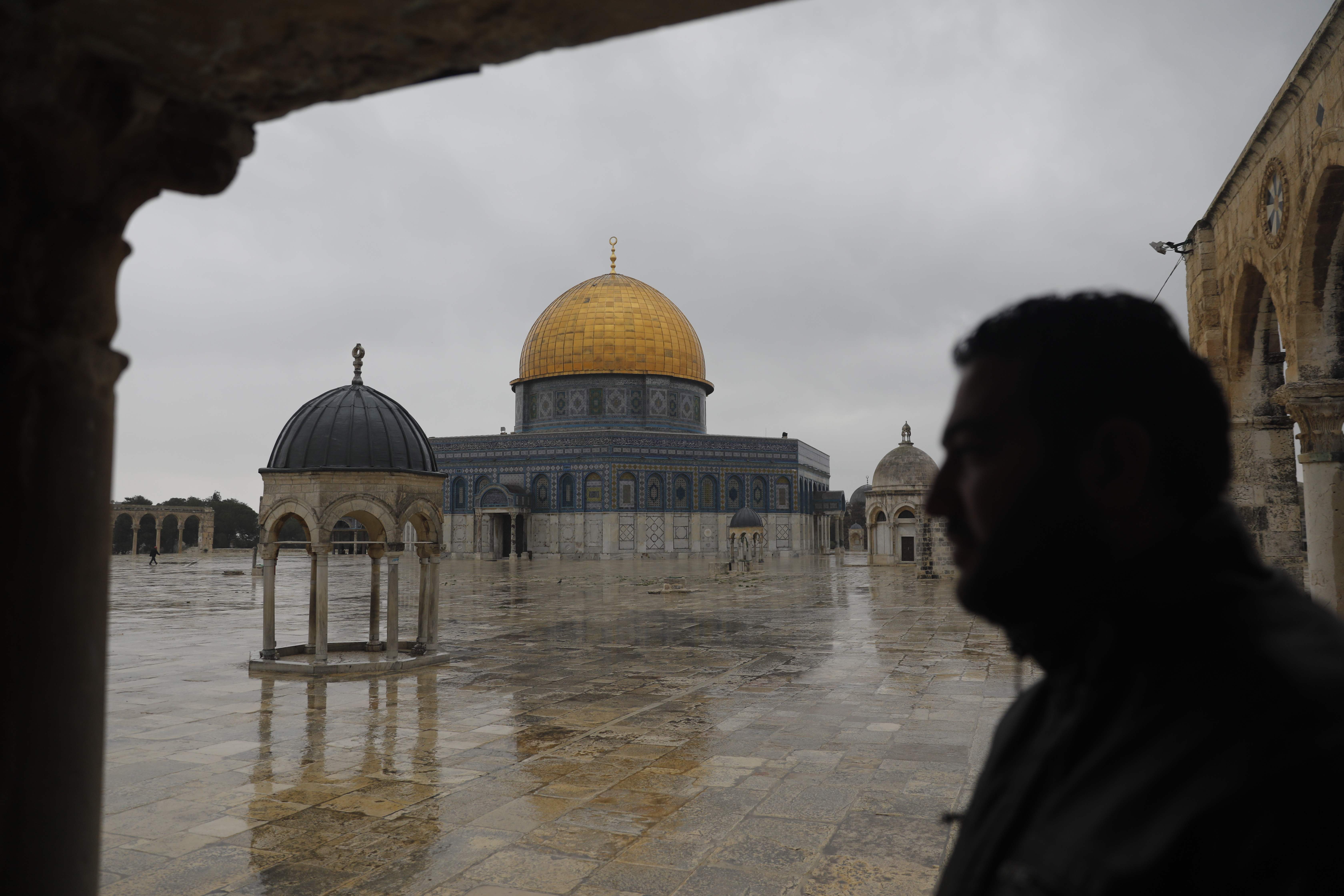 Seorang pria berdiri di depan pelataran Masjid Al-Aqsa yang sempat tutup akibat pandemi covid-19.