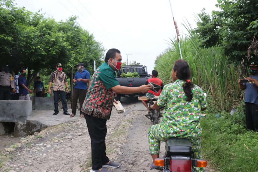 Pemudik melintas di jalan Desa Getas, Kecamatan Kradenan, Kabupaten Blora yang kondisinya berat dan tidak beraspal.