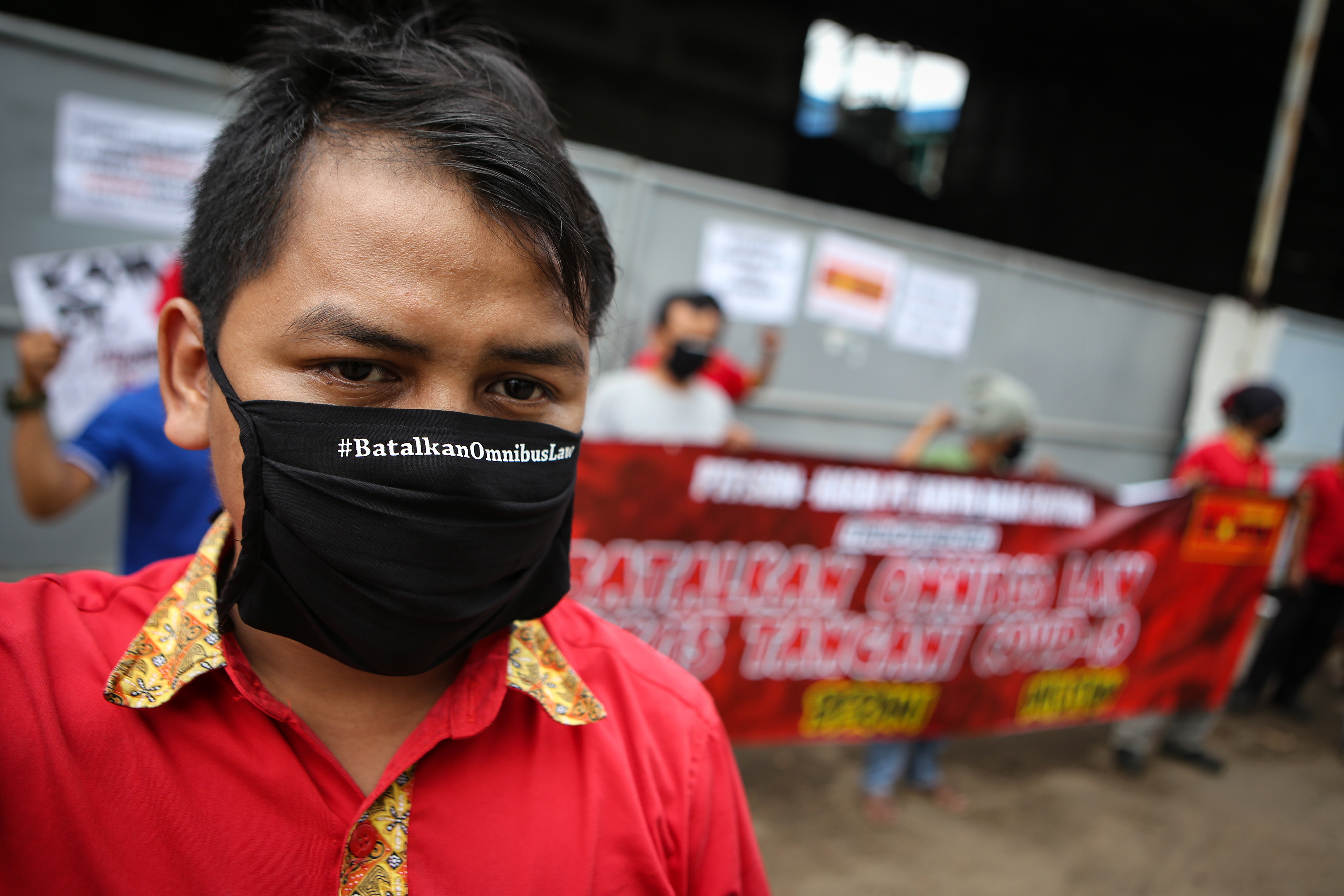 Buruh menggunakan masker bertuliskan #BatalkanOmnibusLaw saat berunjuk rasa di Hari Buruh 2020