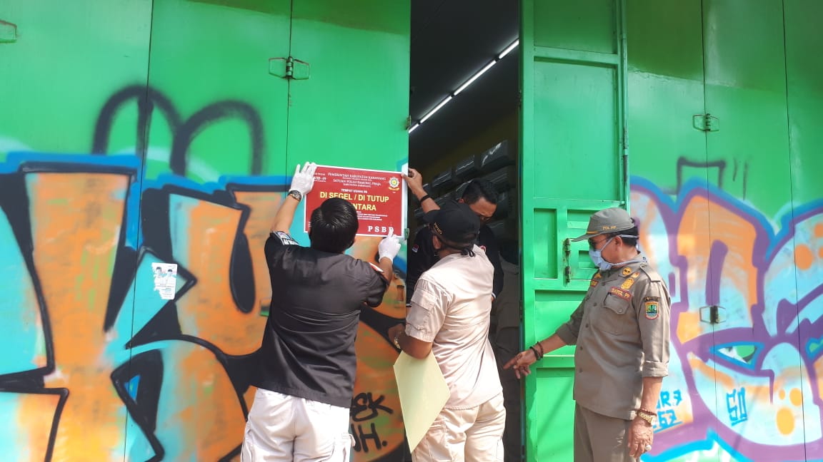 Petugas Satpol PP Karawang, Jawa Barat menutup paksa toko non sembako dan non medis yang masih buka saat PSBB.