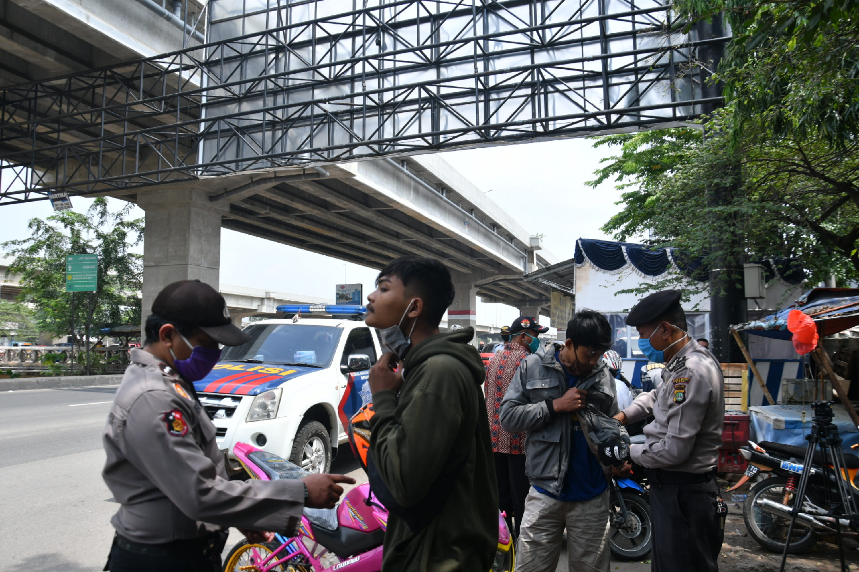 Petugas gabungan POLRI dan Dishub memeriksa warga yang terlihat akan mudik di Jl Raya Kalimalang, perbatasan Jakarta-Bekasi
