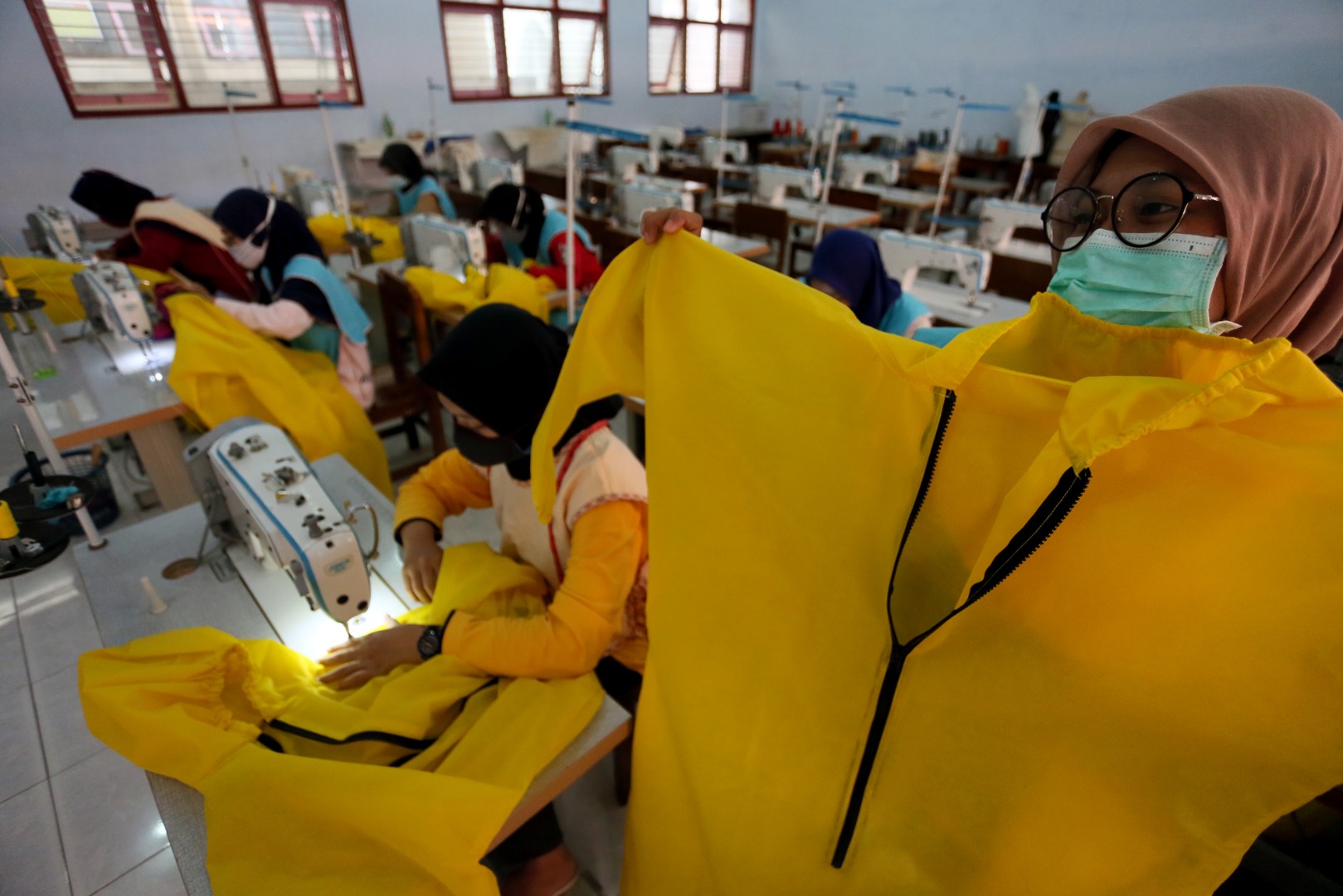 Sisiwa SMK memproses pembuatan baju pelindung diri (Hazmat Suit) di SMKN 2 Blitar, Jawa Timur, Kamis (9/4). 