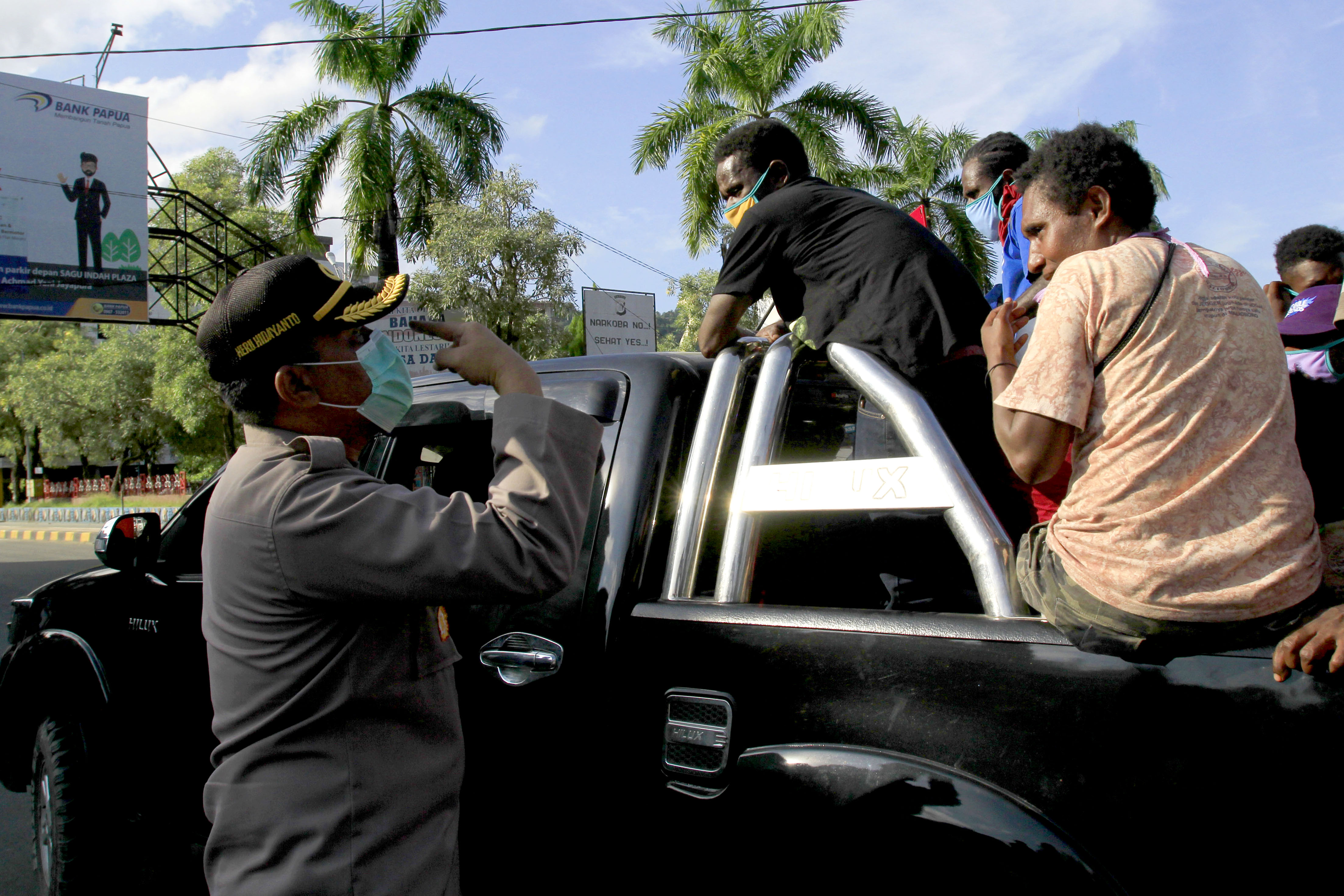 Seorang petugas kepolisian memberikan imbauan kepada masyarakat untuk mengenakan masker di Taman Imbi, Jayapura, Papua, Senin (18/5/2020)