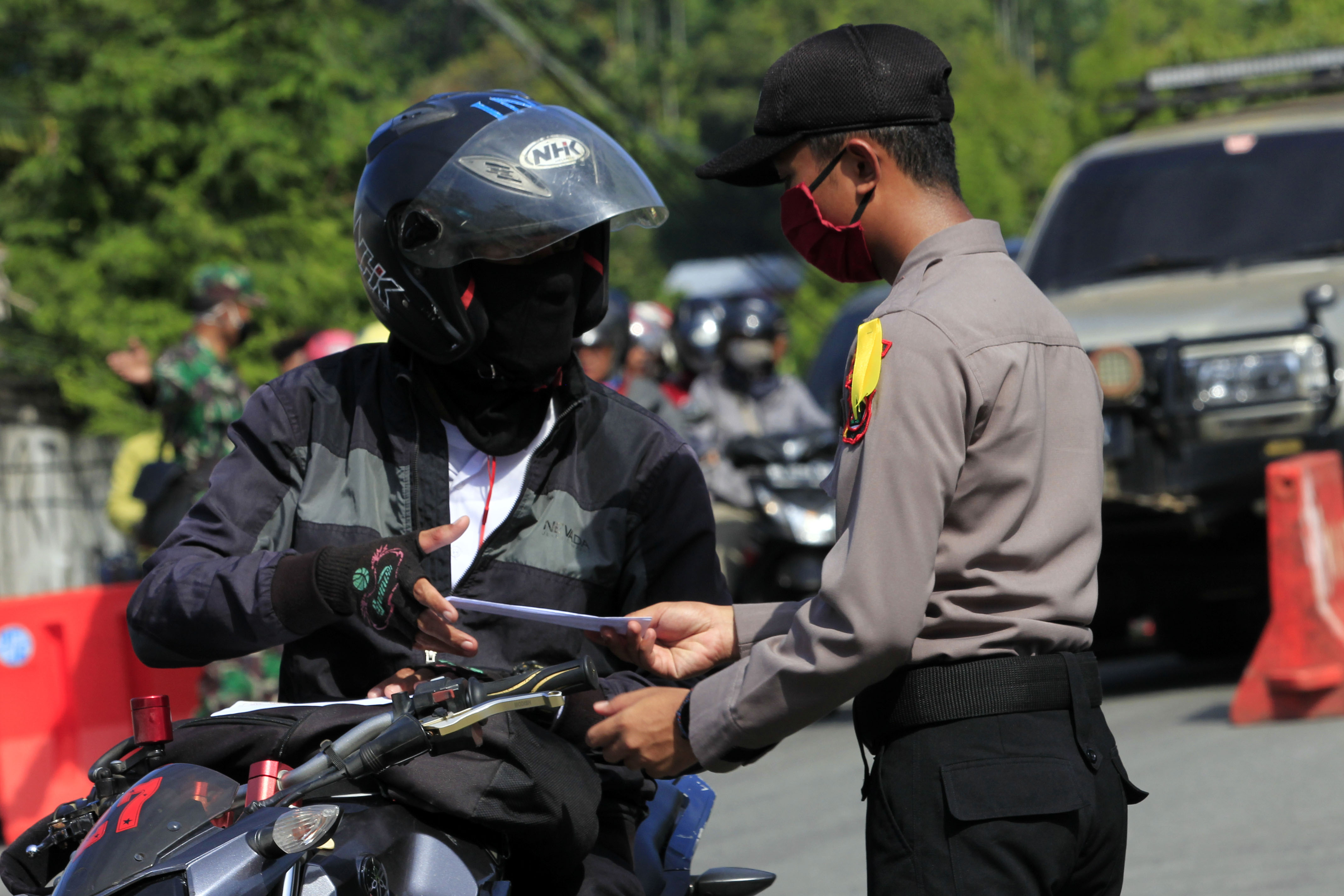 Petugas kepolisian memeriksa surat kelengkapan pengendara sepeda motor di Jayapura, Papua, Senin (18/5). 
