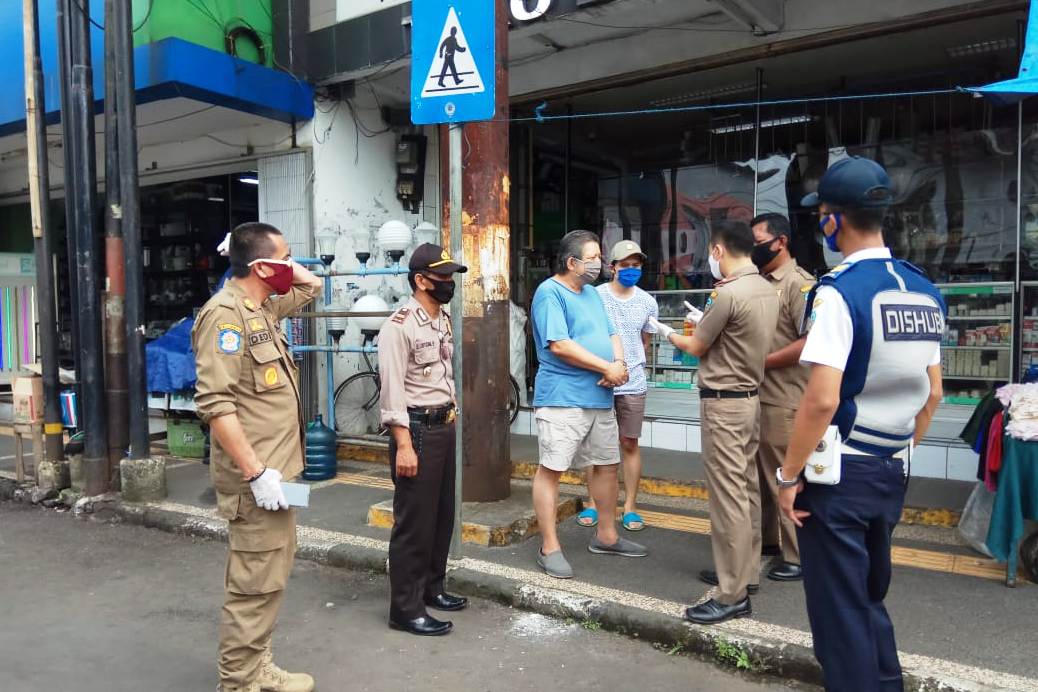 Satpol PP Kota Tasikmalaya menutup paksa ratusan pertokoan di hari pertama PSBB di sepanjang Jalan HZ Mustofa.