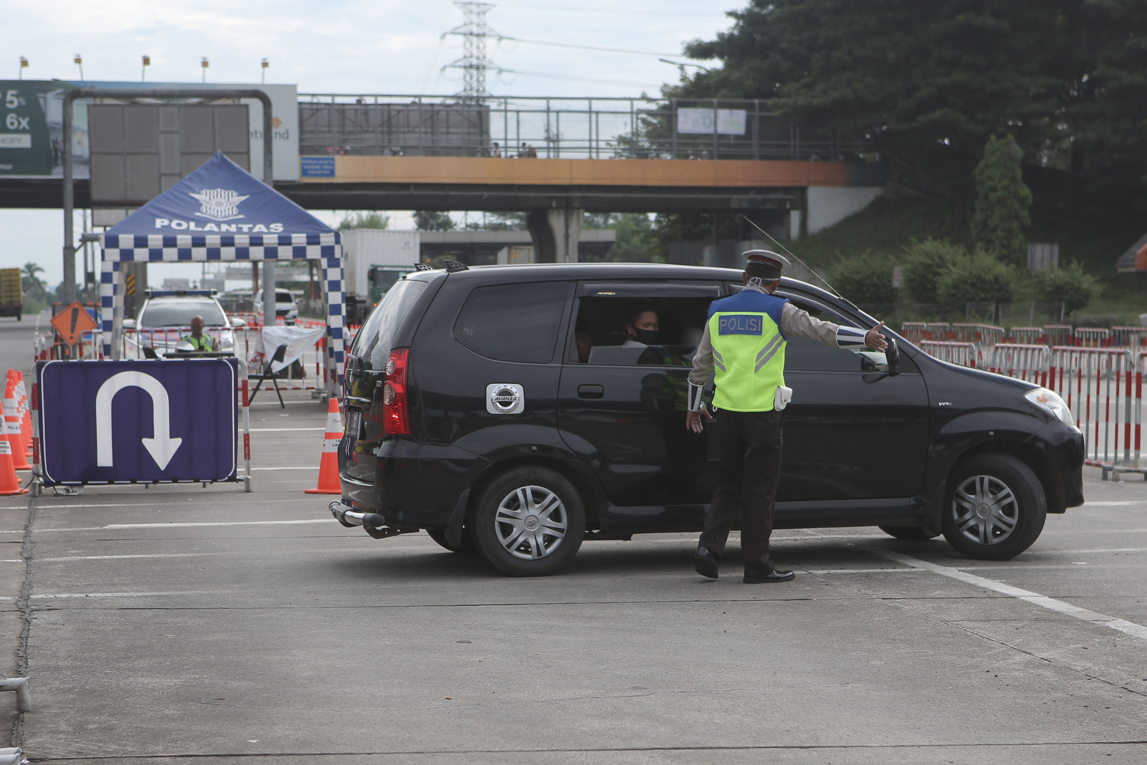 Petugas Kepolisian memerintahkan pengemudi putar arah kembali ke Jakarta di gerbang Tol Cikupa Tangerang (21/5/2020)