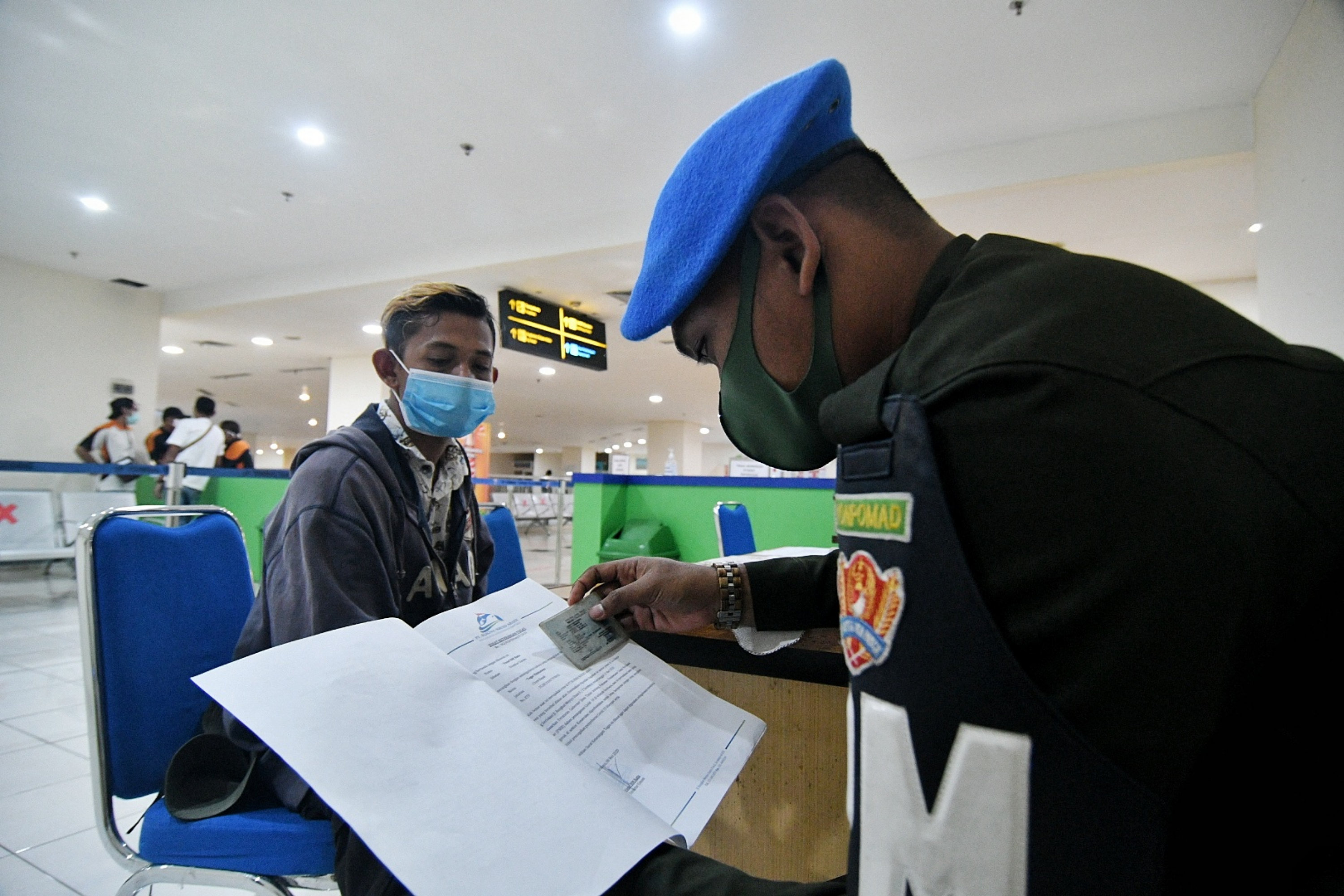 Petugas melakukan pengecekan berkas perjalanan penumpang di Terminal Pulo Gebang, Minggu (10/5).