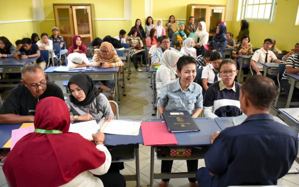 Sejumlah siswa dan orang tua murid saat mendaftar seleksi Penerimaan Peserta Didik Baru (PPDB) DKI Jakarta, Senin (24/6/2019). 
