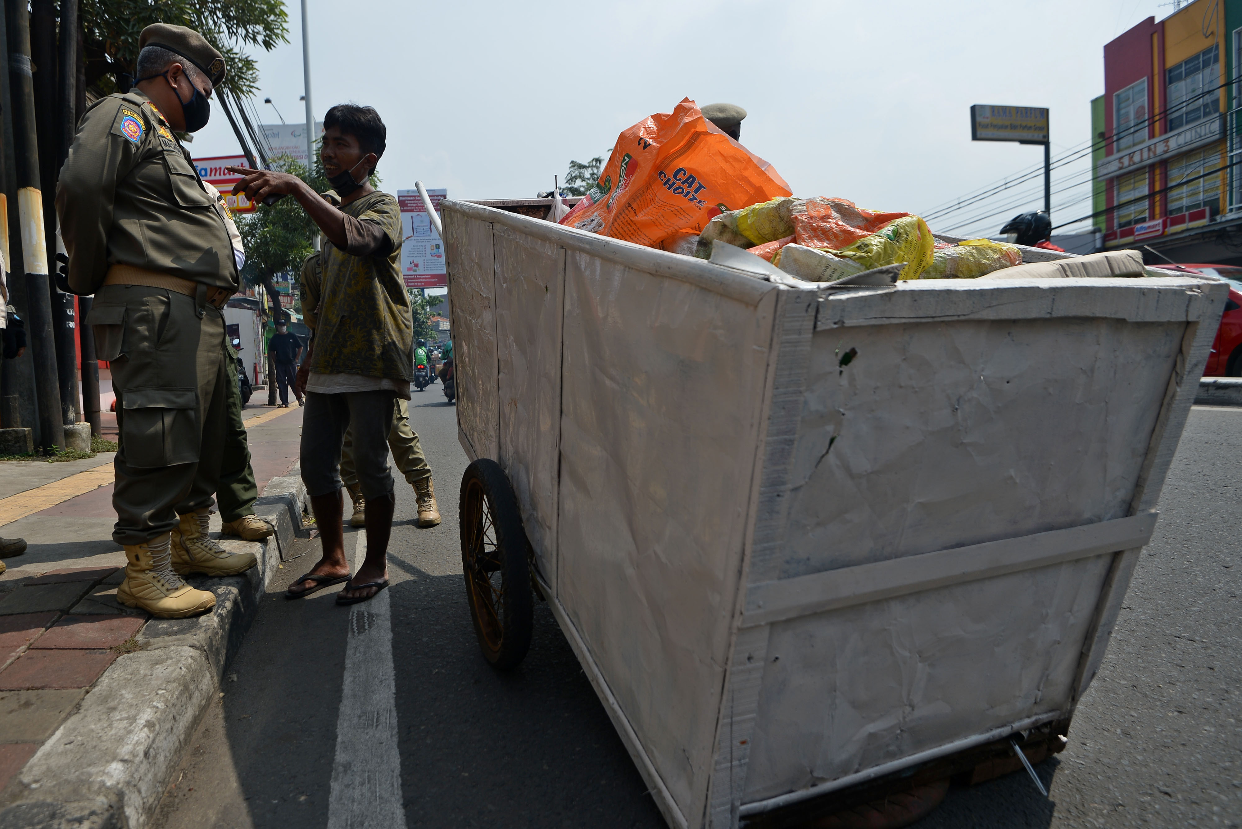  Petugas Satpol PP menginterogasi warga penyandang masalah kesejahteraan sosial (PMKS) di Jalan Dewi Sartika, Cawang, Jakarta