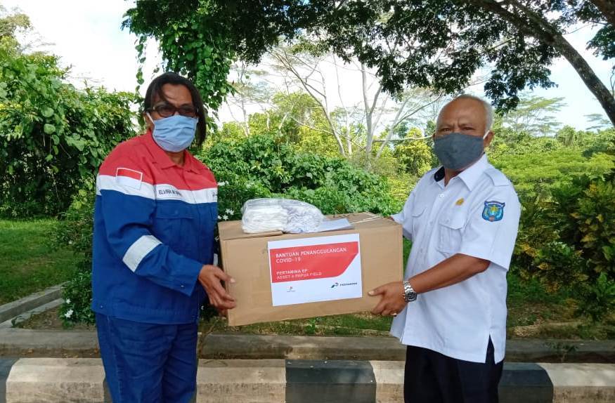 Kepala Distrik Aimas Yuri (kanan) membagikan masker bantuan PT Pertamina EP kepada penjual pinang di Pasar Pinang Alun-Alun Kab Sorong.