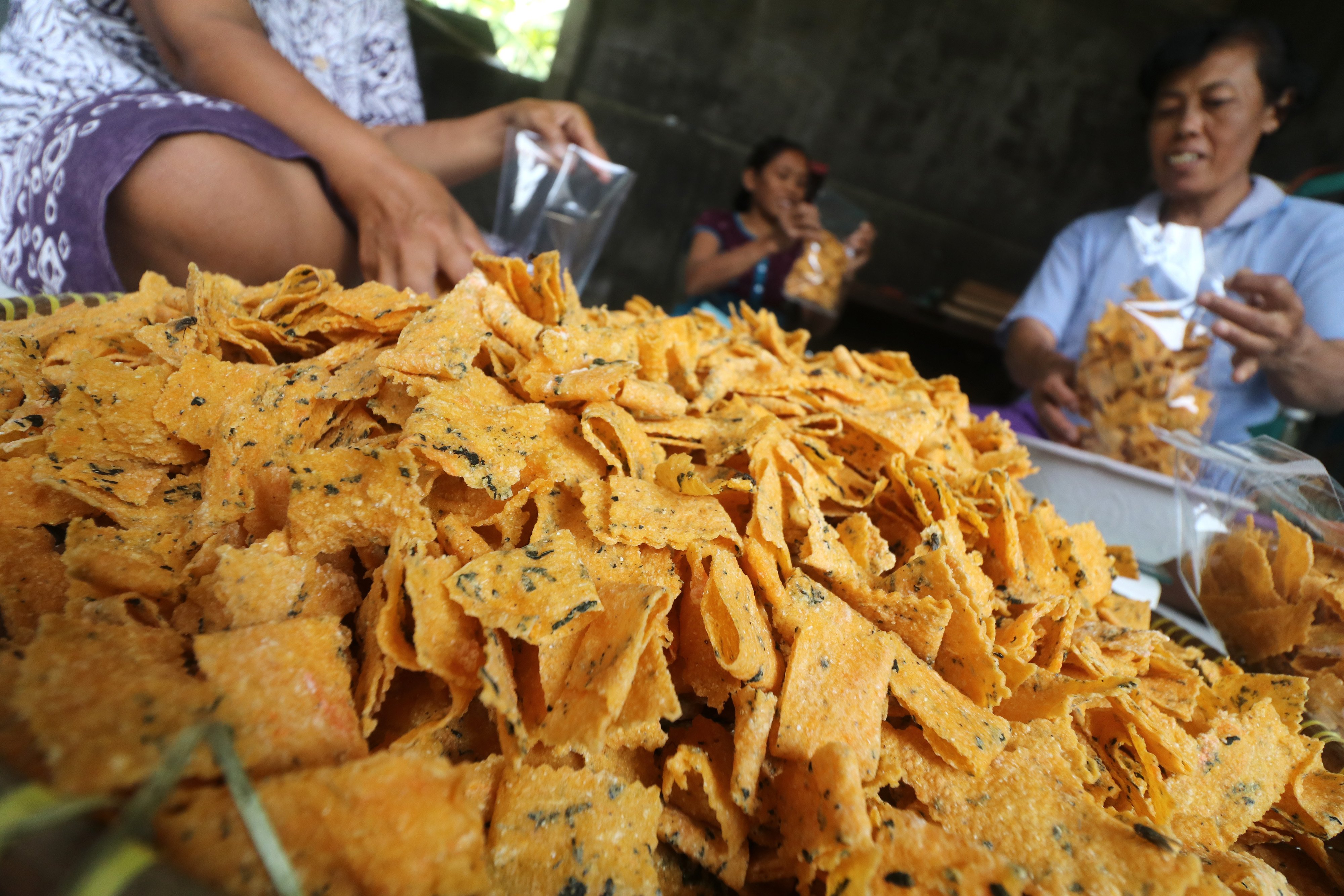 Pekerja memasukkan kerupuk yang terbuat dari ampok (nasi jagung) ke dalam kantong plastik di Desa Nanggungan, Kediri, Jawa Timur.