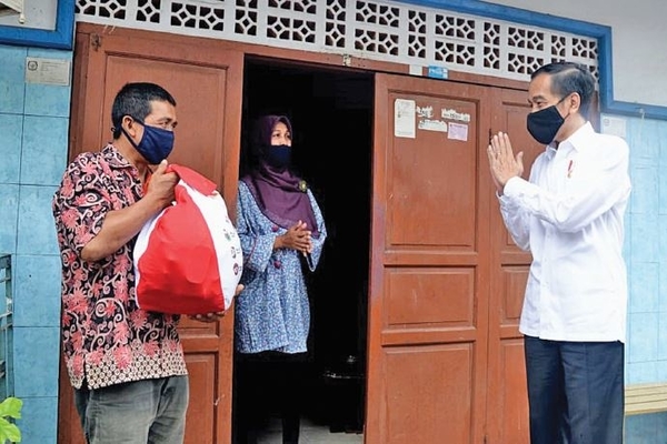 residen Joko Widodo berbincang dengan keluarga penerima manfaat (KPM) distribusi sembako tahap ke-3 di Kecamatan Johar Baru, Jakarta Pusat, 