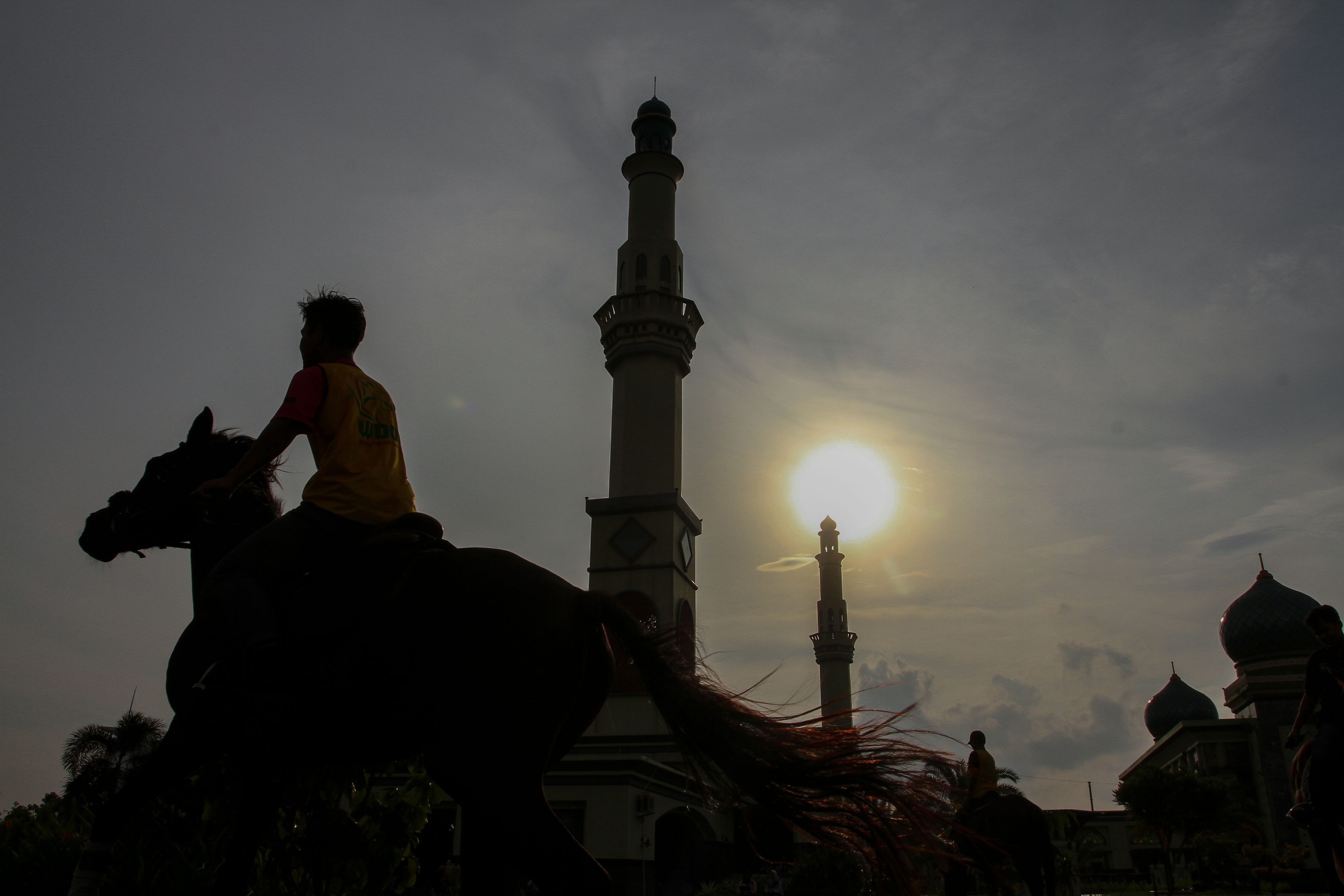 Pengunjung menunggang kuda yang disediakan saat program wisata berkuda di Masjid Raya An-nur Pekanbaru, Riau, Selasa (14/5)