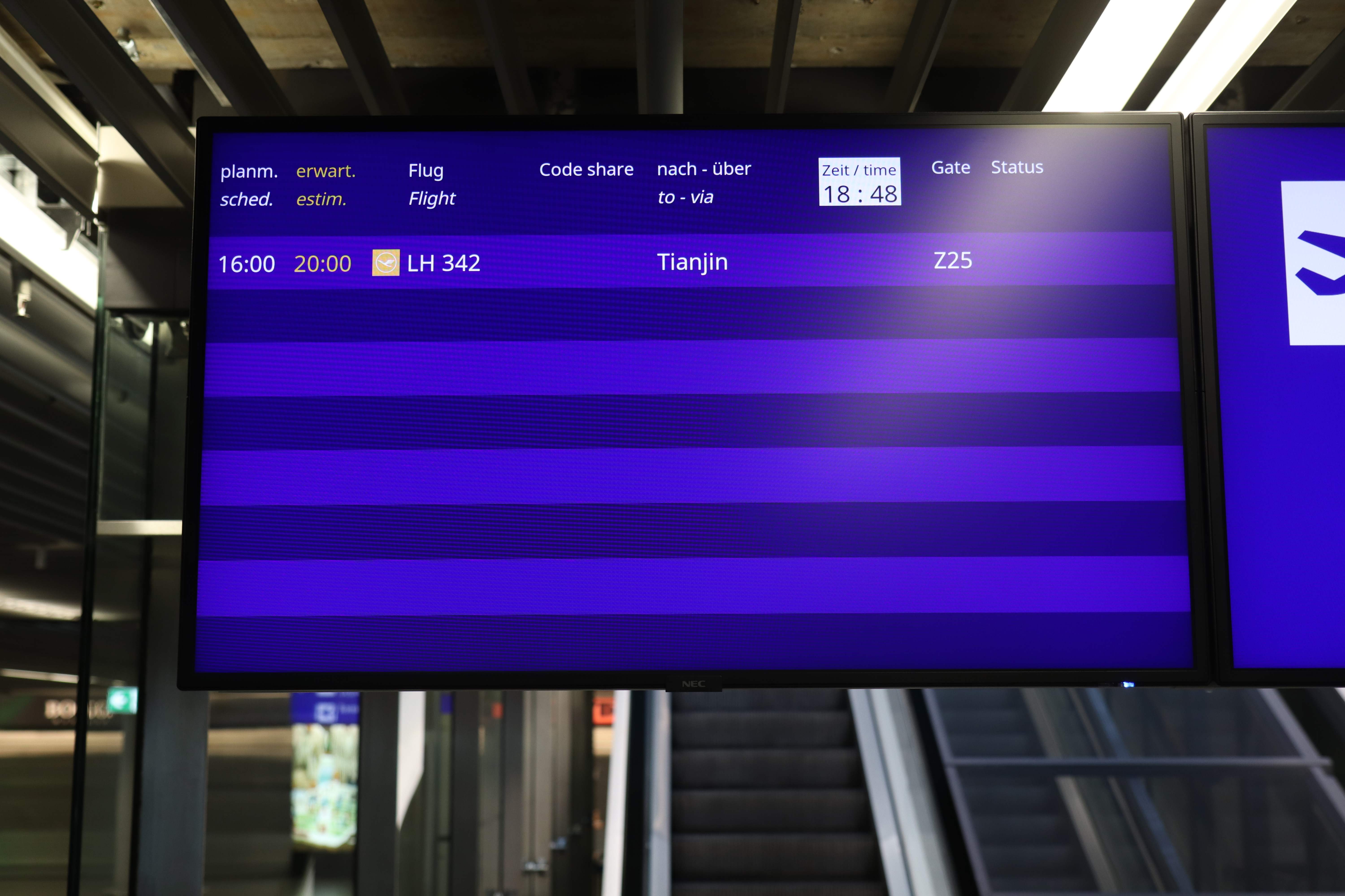 Sebuah papan pengumuman menunjukkan penerbangan Lufthansa ke Tianjin, Tiongkok, di Bandara Frankfurt, Jerman.