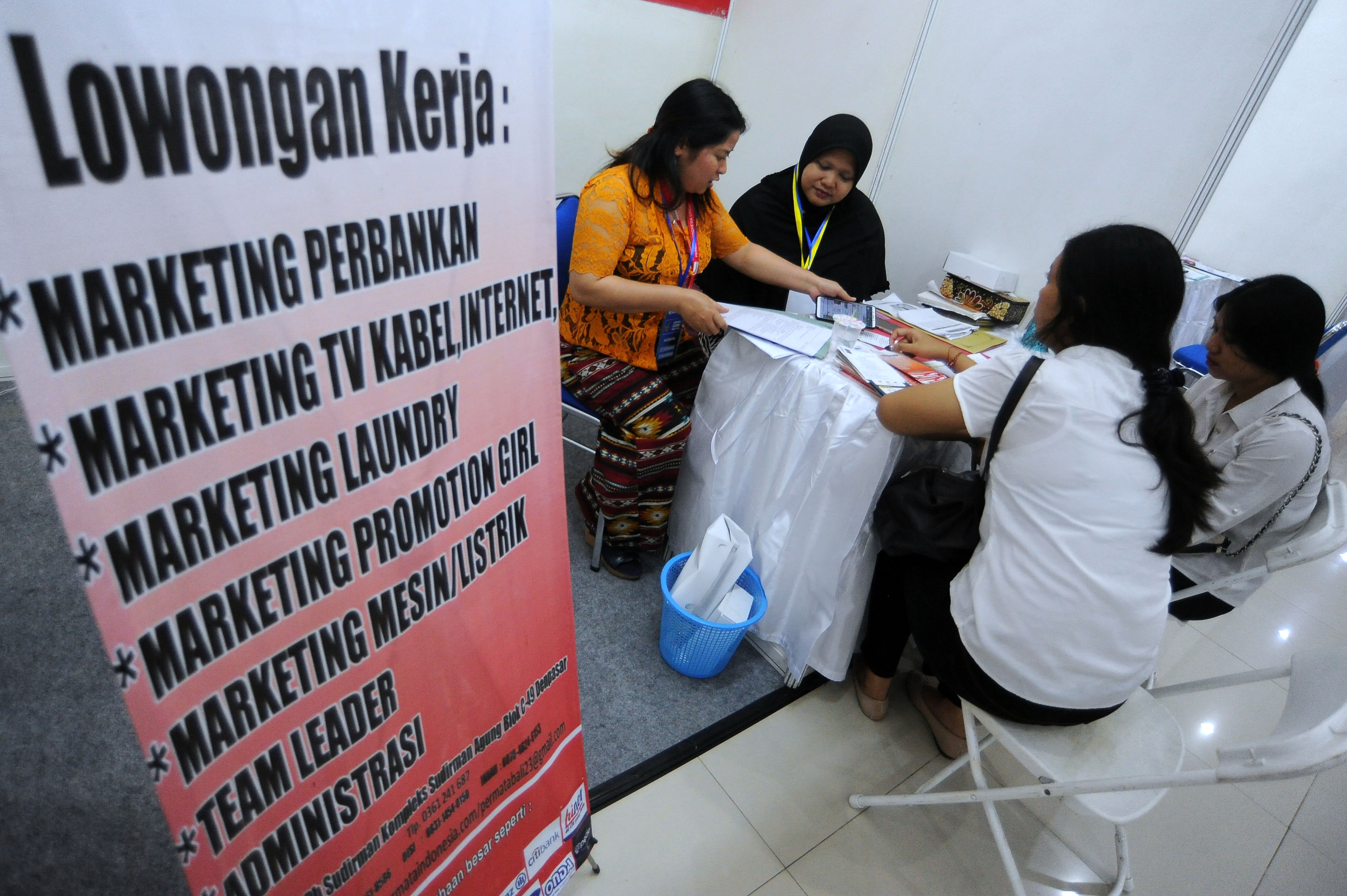 Karyawan perusahaan memberikan informasi kepada pencari kerja.