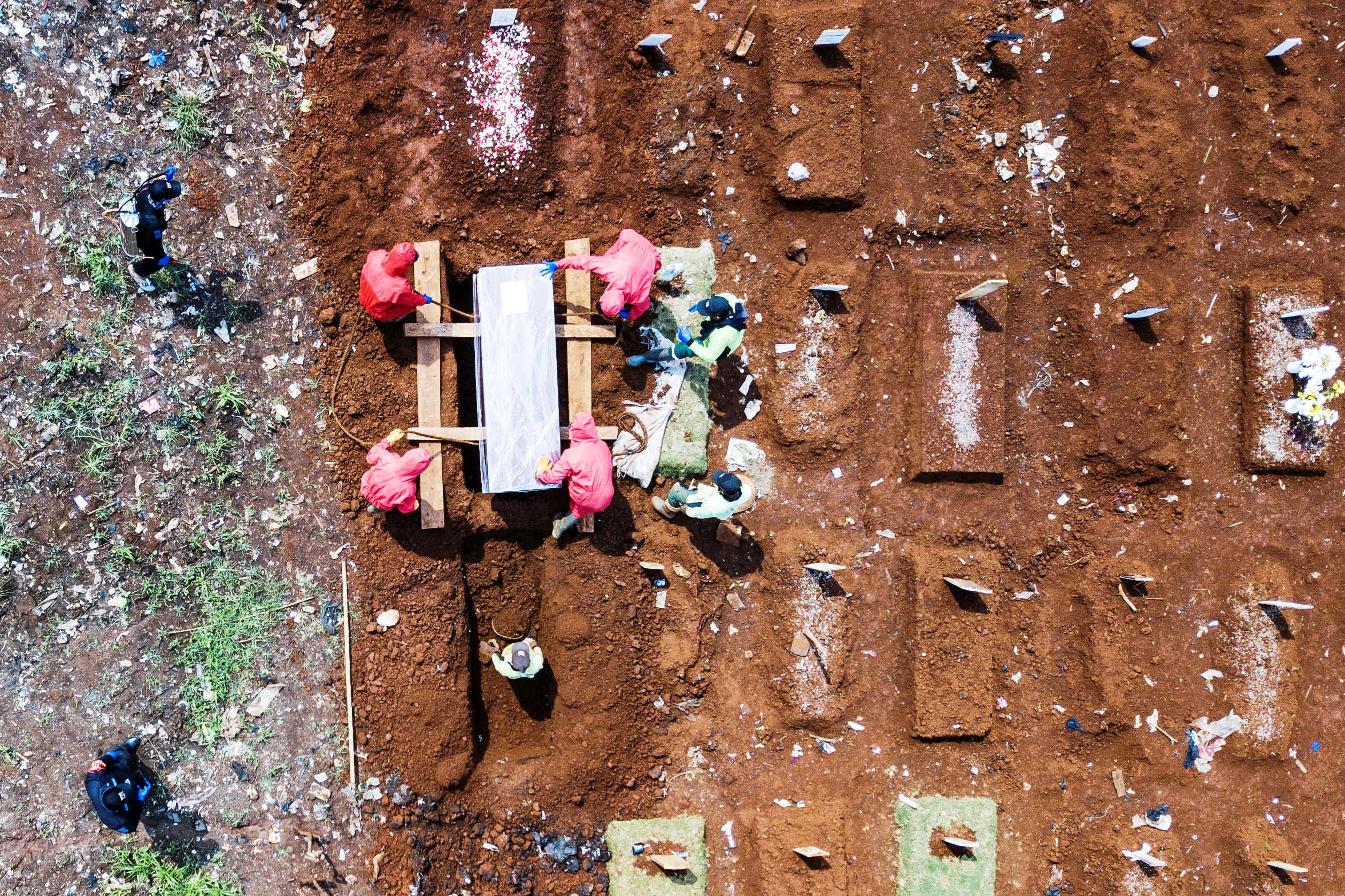 Petugas sedang memakamkan jenazah Covid.