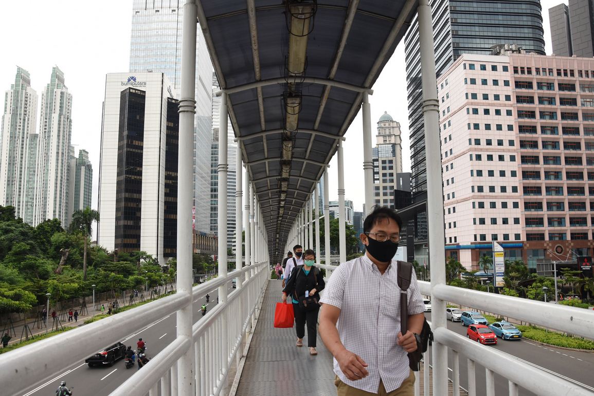 Pekerja berjalan di atas JPO Dukuh Atas, Jakarta, Senin (4/5/2020). 