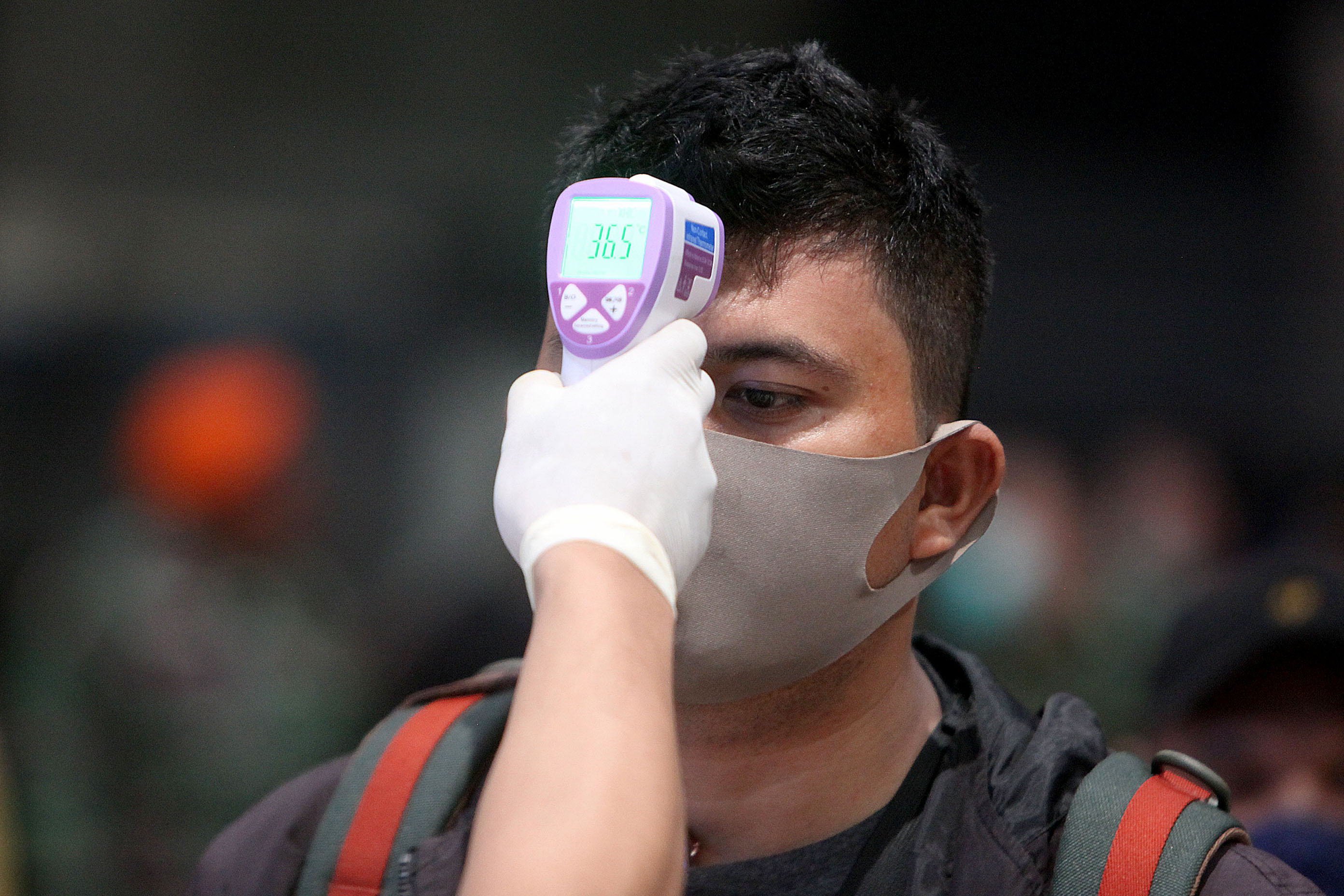 Petugas Bandara memeriksa kesehatan calon penumpang yang hendak berangkat