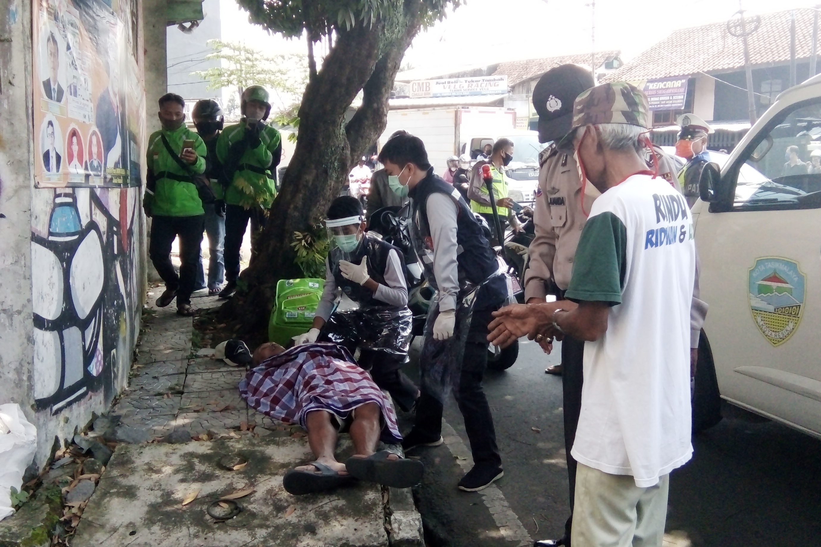 Petugas berpakaian APD dibantu anggota TNI dan Polri mengevakuasi jenazah seorang tukang becak yang meninggal diduga karena korona. 