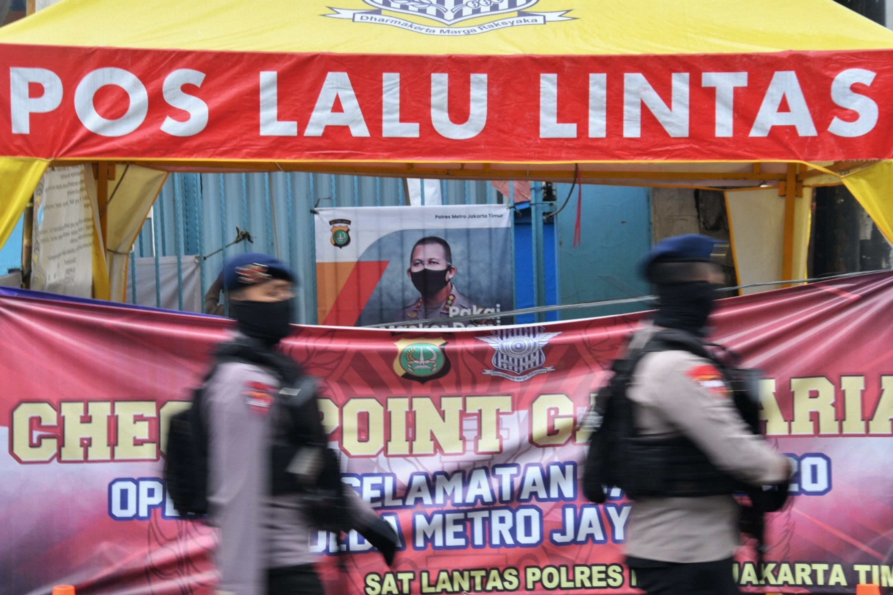 Petugas melakukan pengawasan di check point  di Jl Raya Bogor, perbatasan Jakarta Timur-Depok