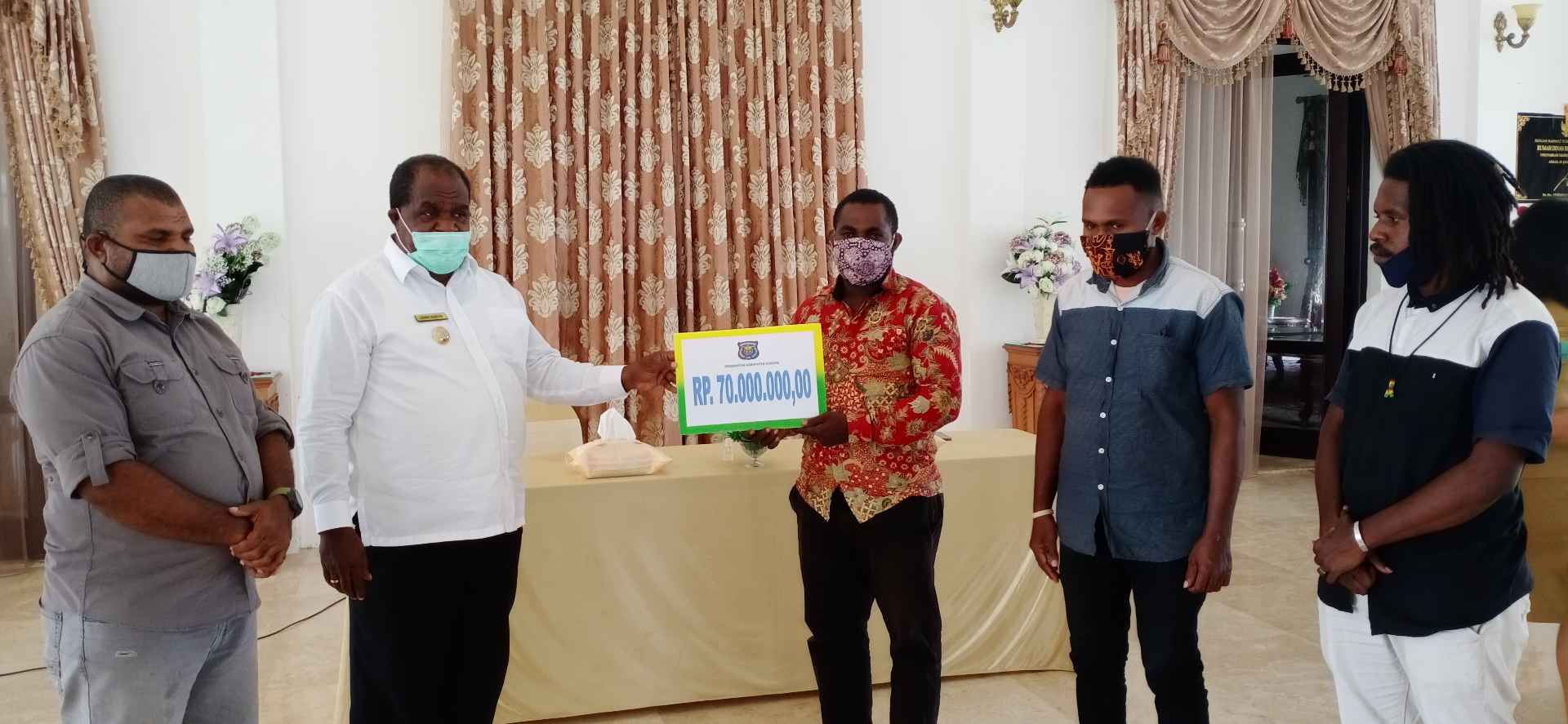 Bupati Sorong Johny Kamuru menyerahkan bantuan kepada Ketua Himamsi Yohanes Paa