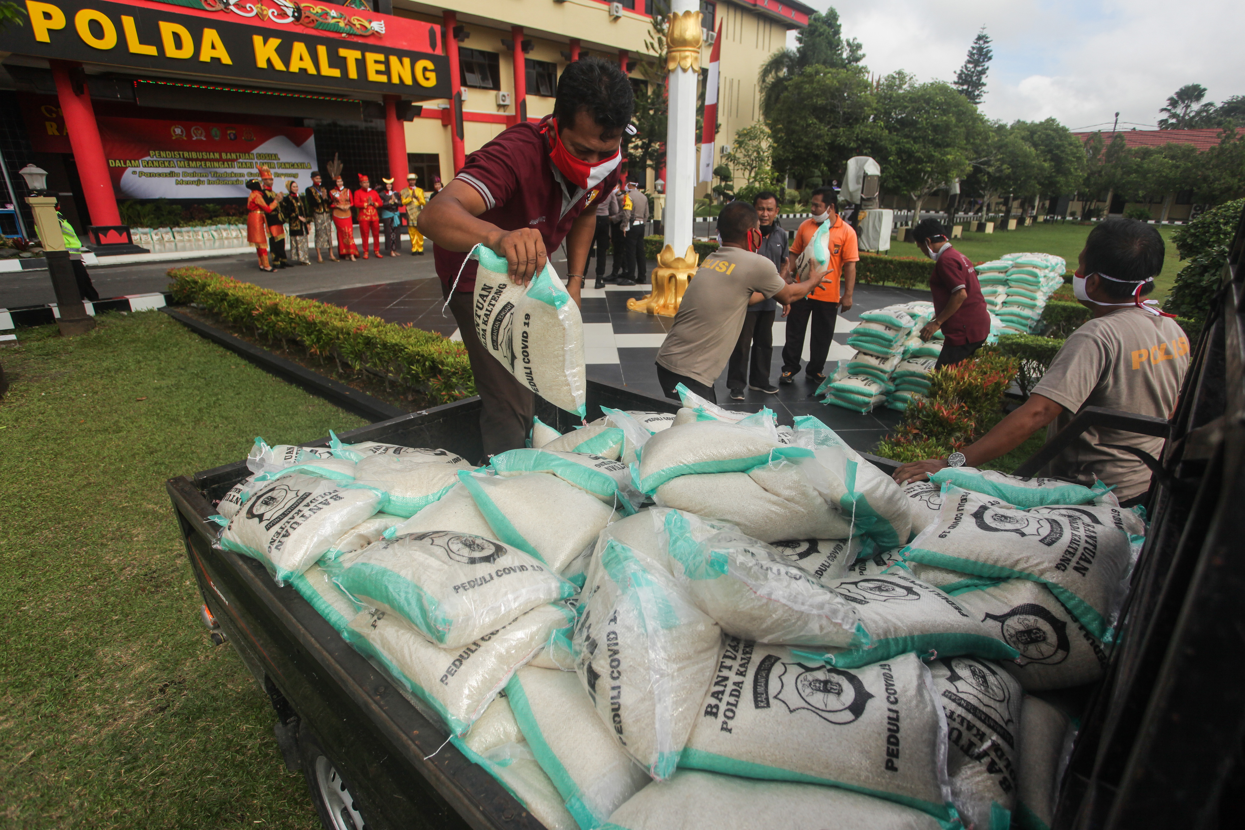 Petugas memindahkan beras bantuan sosial untuk kemudian didistribusikan di Polda Kalteng