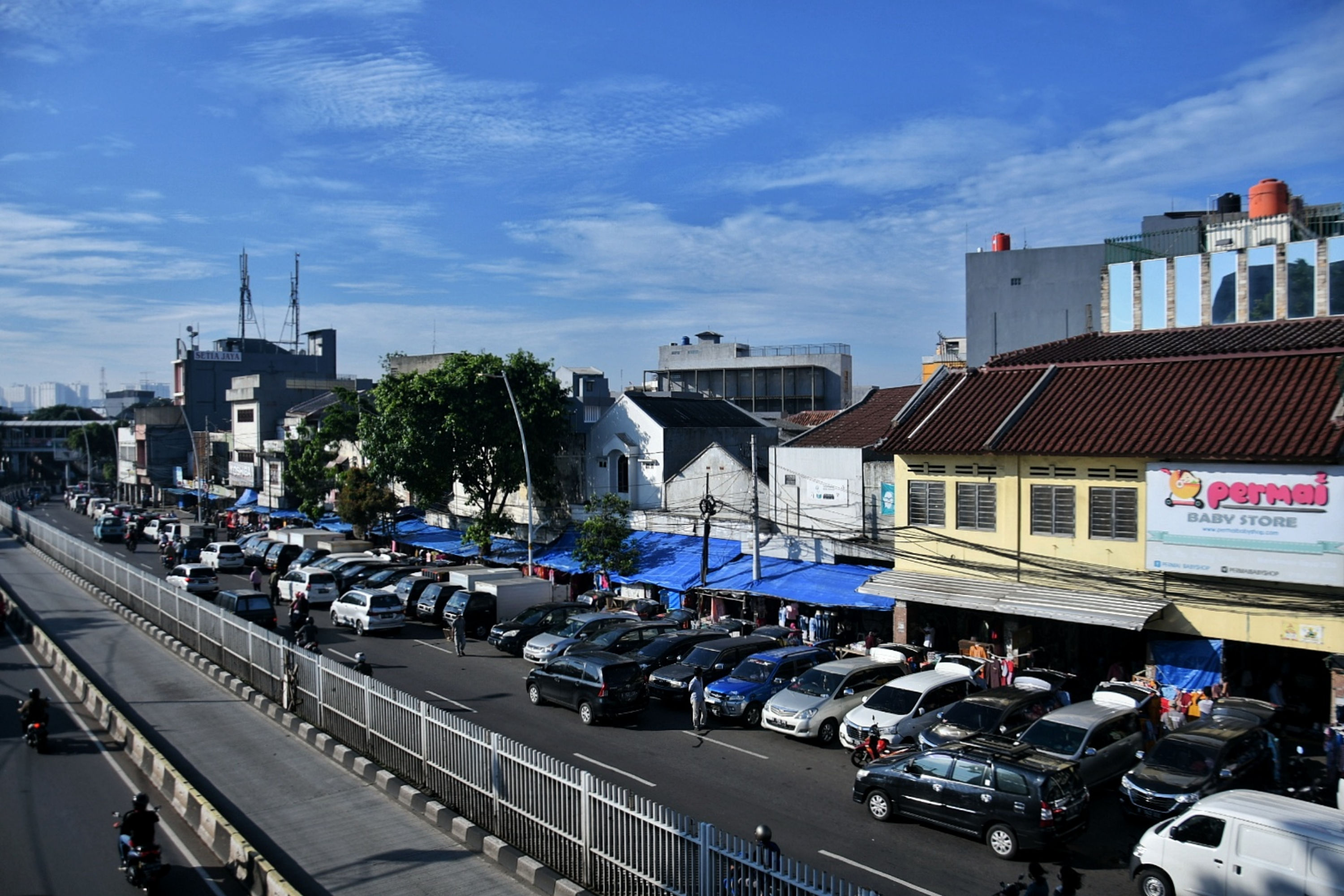 Pedagang menggelar lapak dagangannya menggunakan mobil pribadi di Jalan Matraman Raya, Jatinegara, Jakarta Timur, Selasa (19/5). 