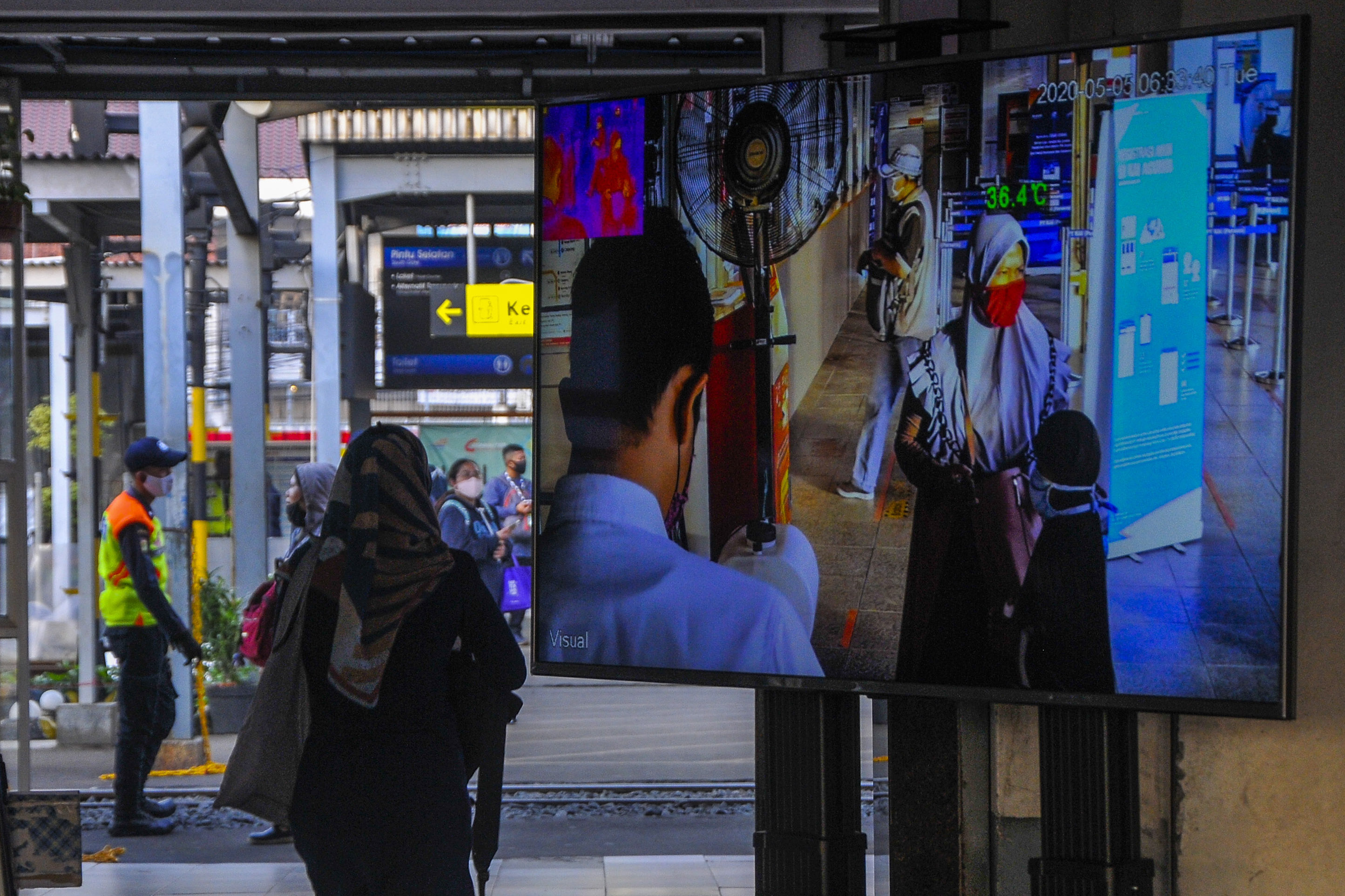 Penumpang melintasi alat pendeteksi suhu tubuh di Stasiun Bekasi, Jawa Barat, Selasa (5/5)